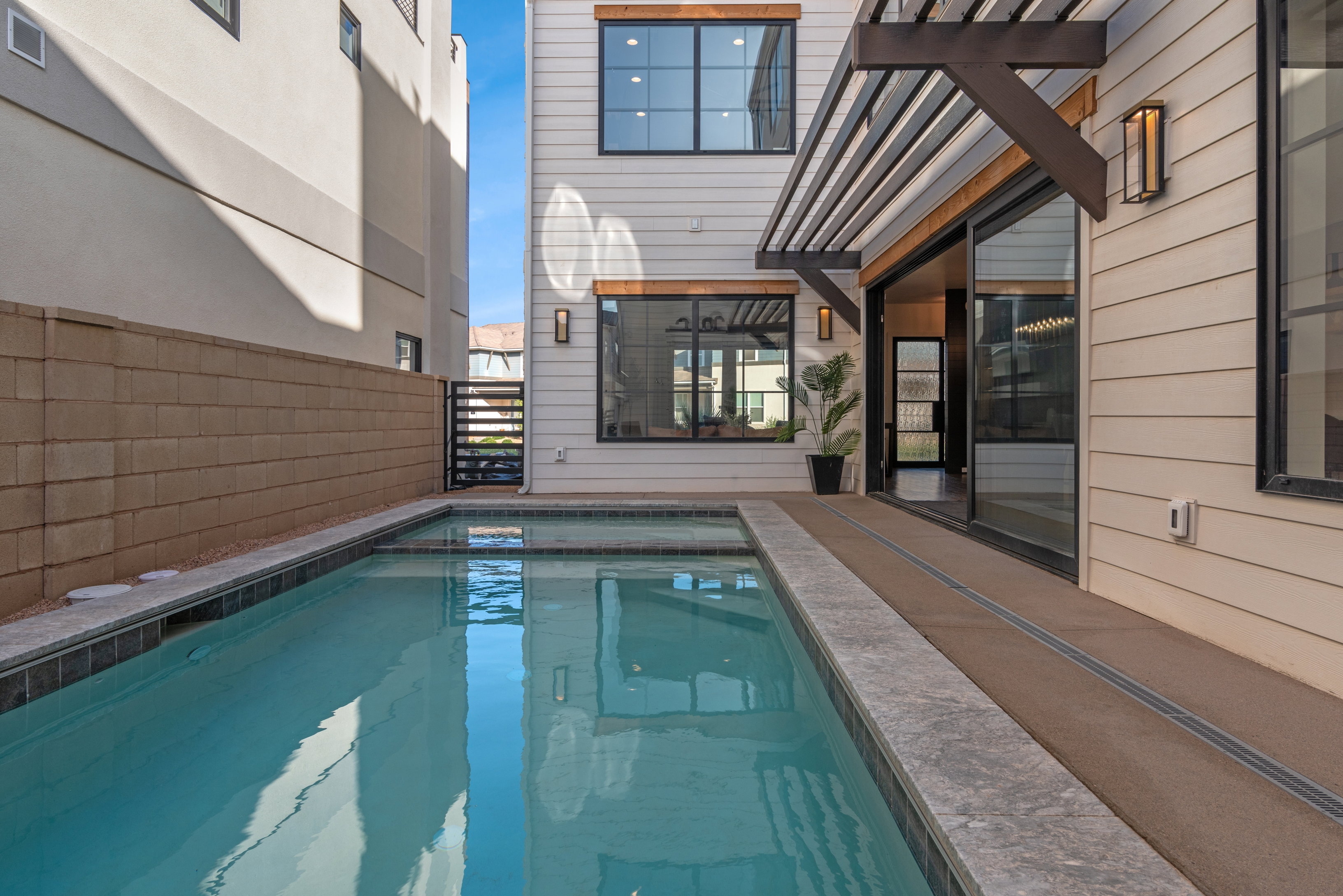 Private courtyard pool with integrated spa and dark tile coping