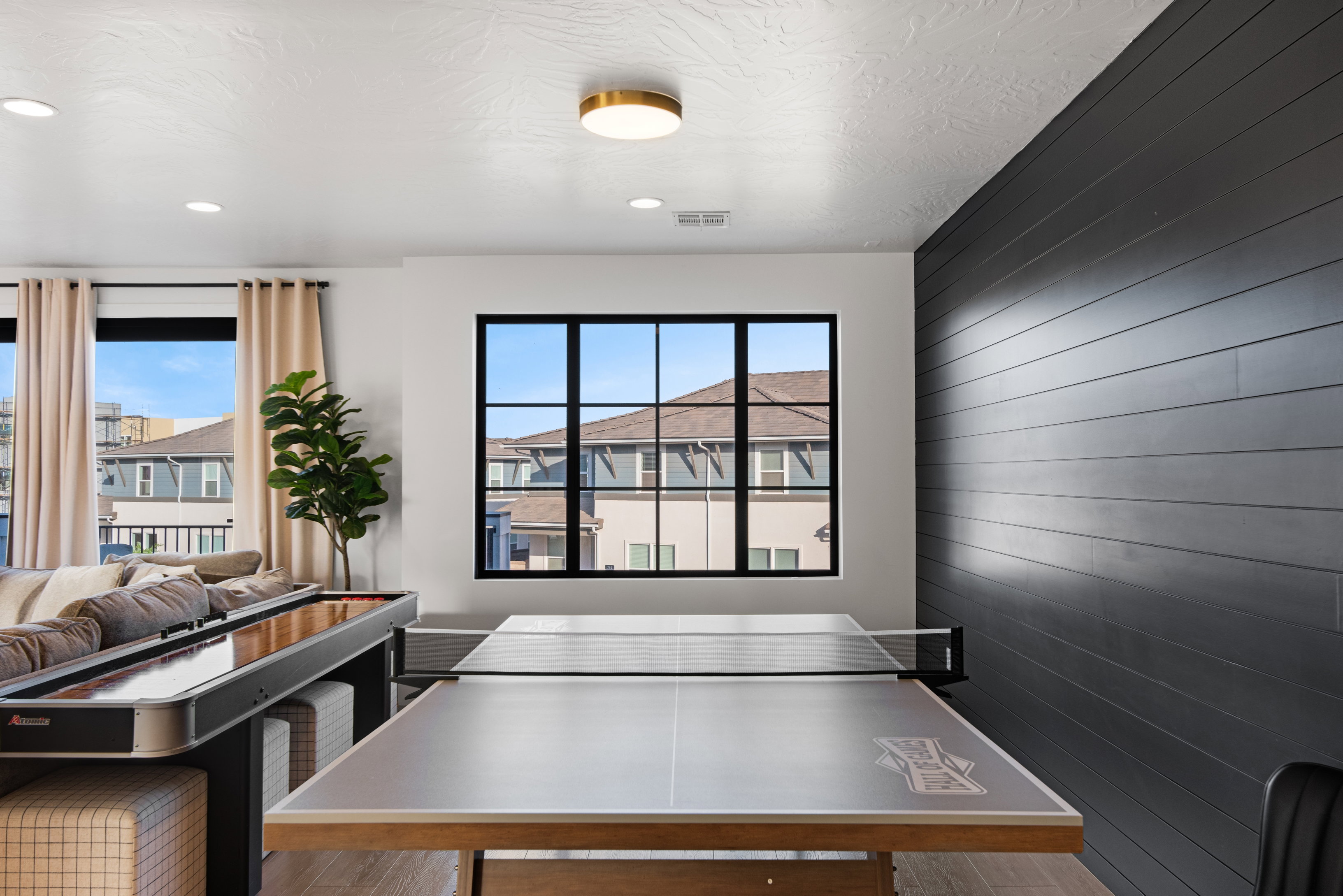 Recreational room featuring a textured accent wall, wood-finish flooring, and recessed lighting