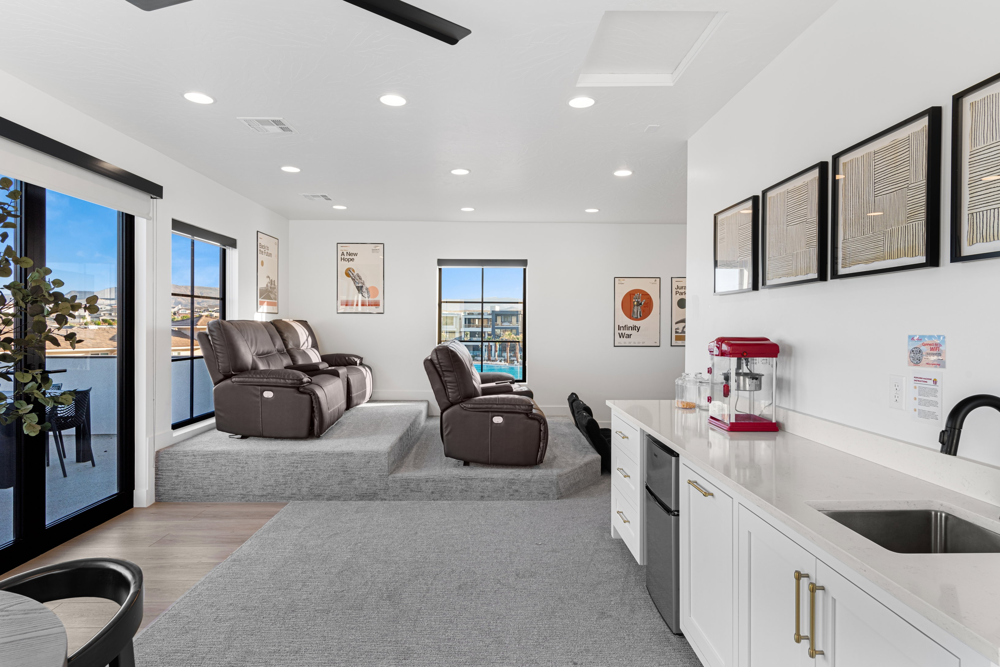 Entertainment area featuring tiered carpeted seating platforms and a built-in wet bar