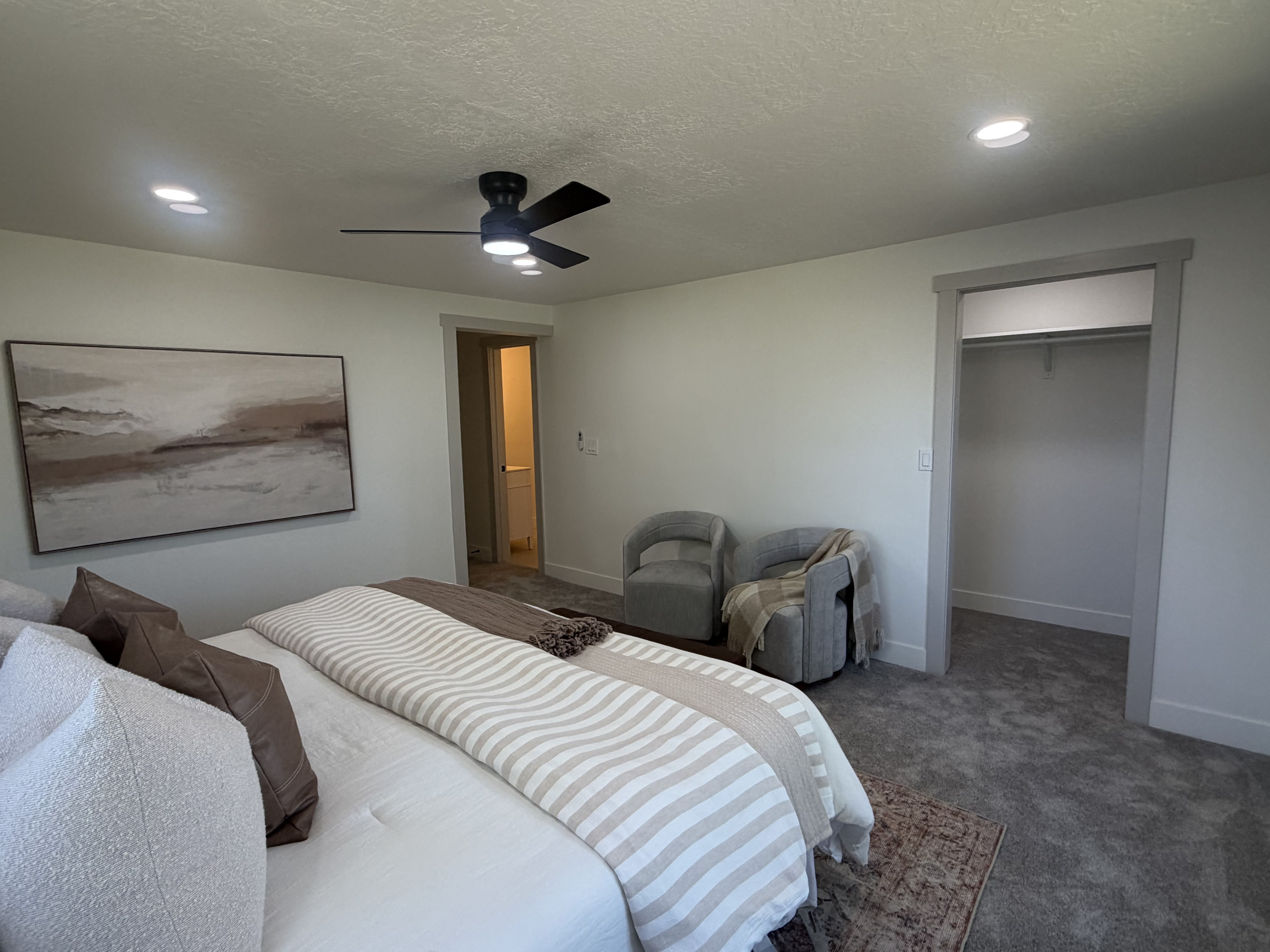 Master bedroom. Plush carpeting throughout with a contemporary ceiling fan and recessed lighting