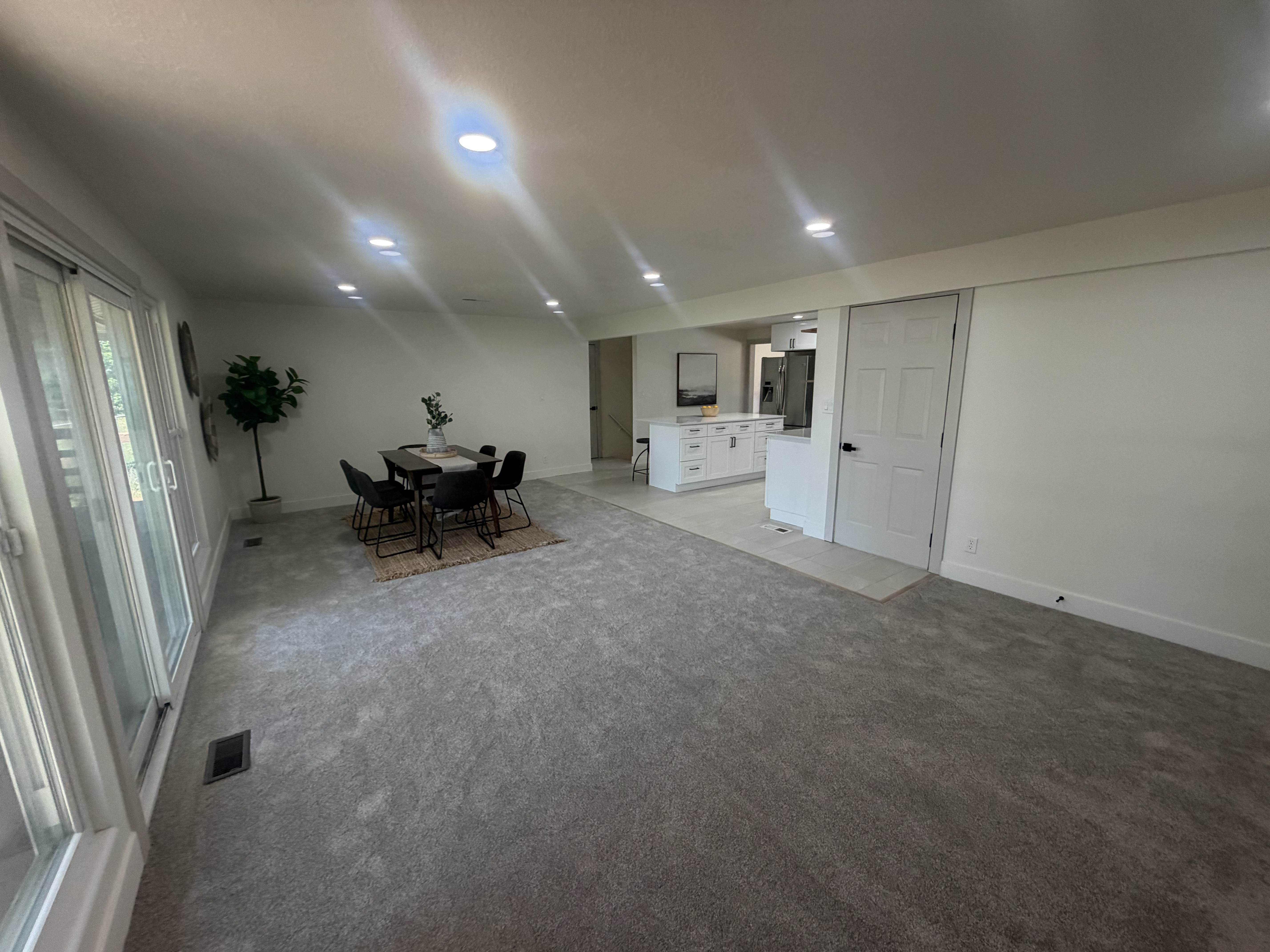 Open-concept living space featuring recessed lighting and light gray carpeting