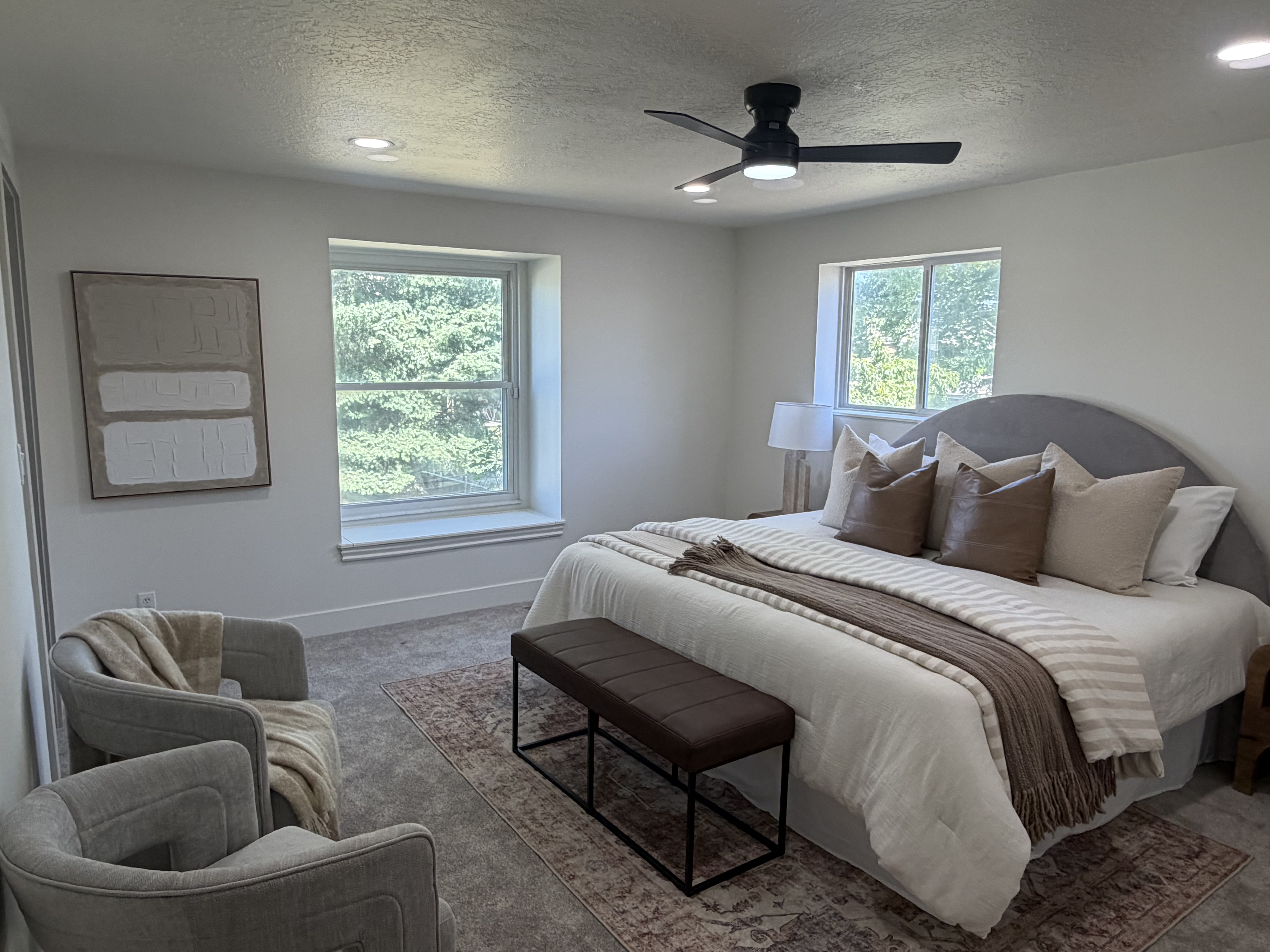 Master bedroom. Carpeted room featuring dual windows, recessed lighting, and a ceiling fan with integrated lighting
