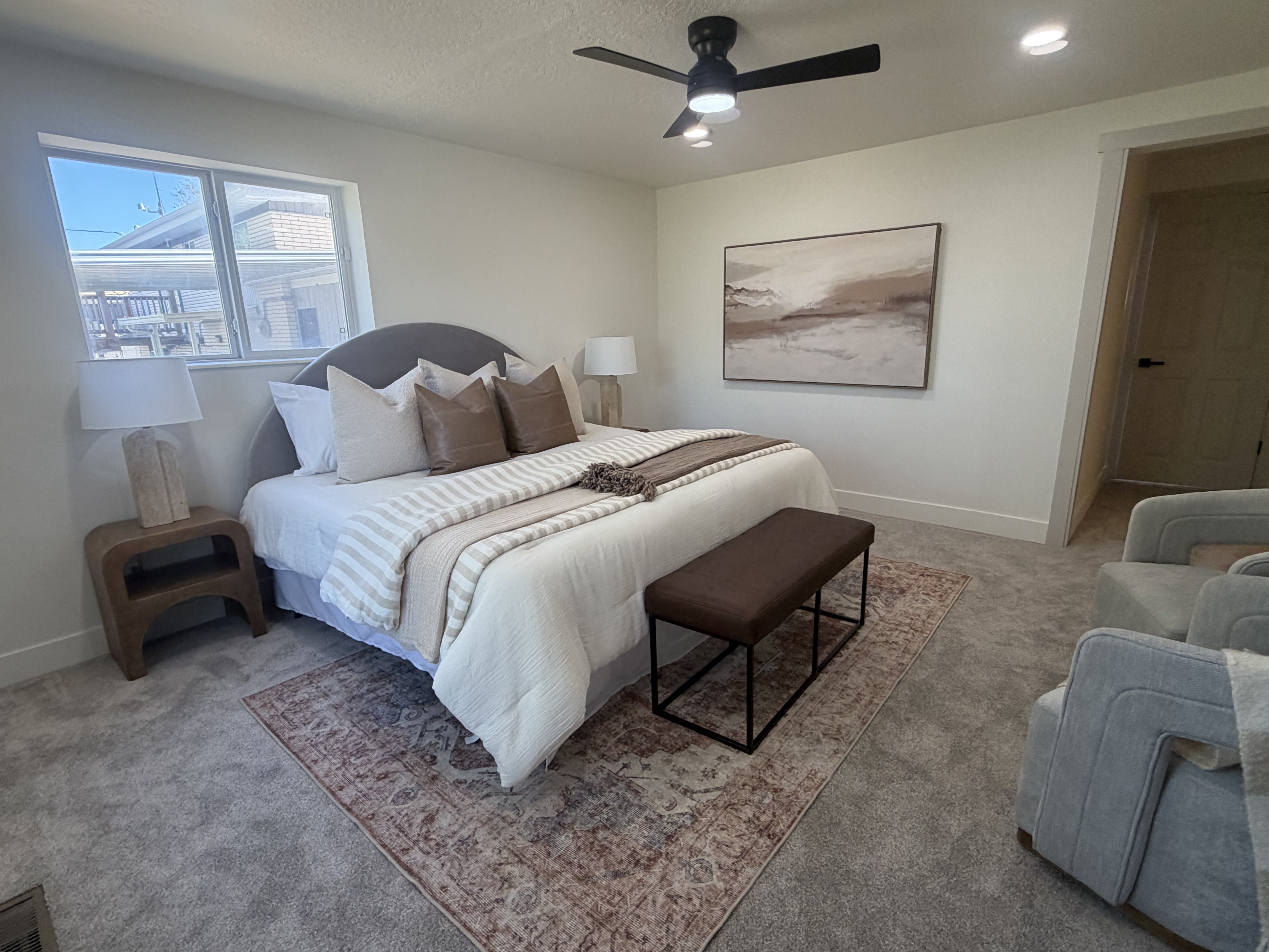 Master bedroom. Spacious room featuring neutral wall tones, plush gray carpeting, a multi-pane window, recessed lighting, and a contemporary ceiling fan