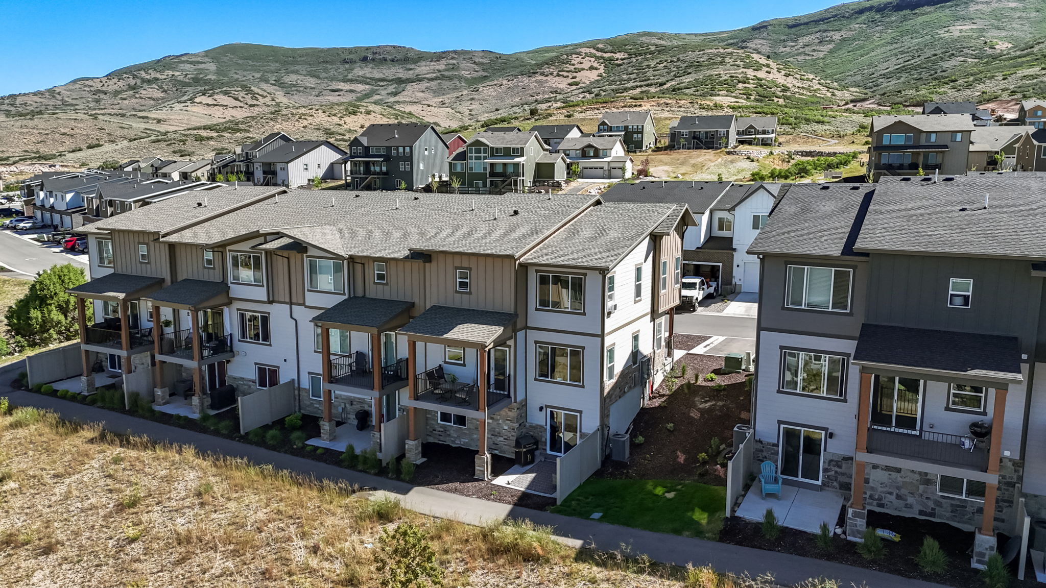Contemporary townhome row featuring multi-level exteriors with contrasting siding and stone accents