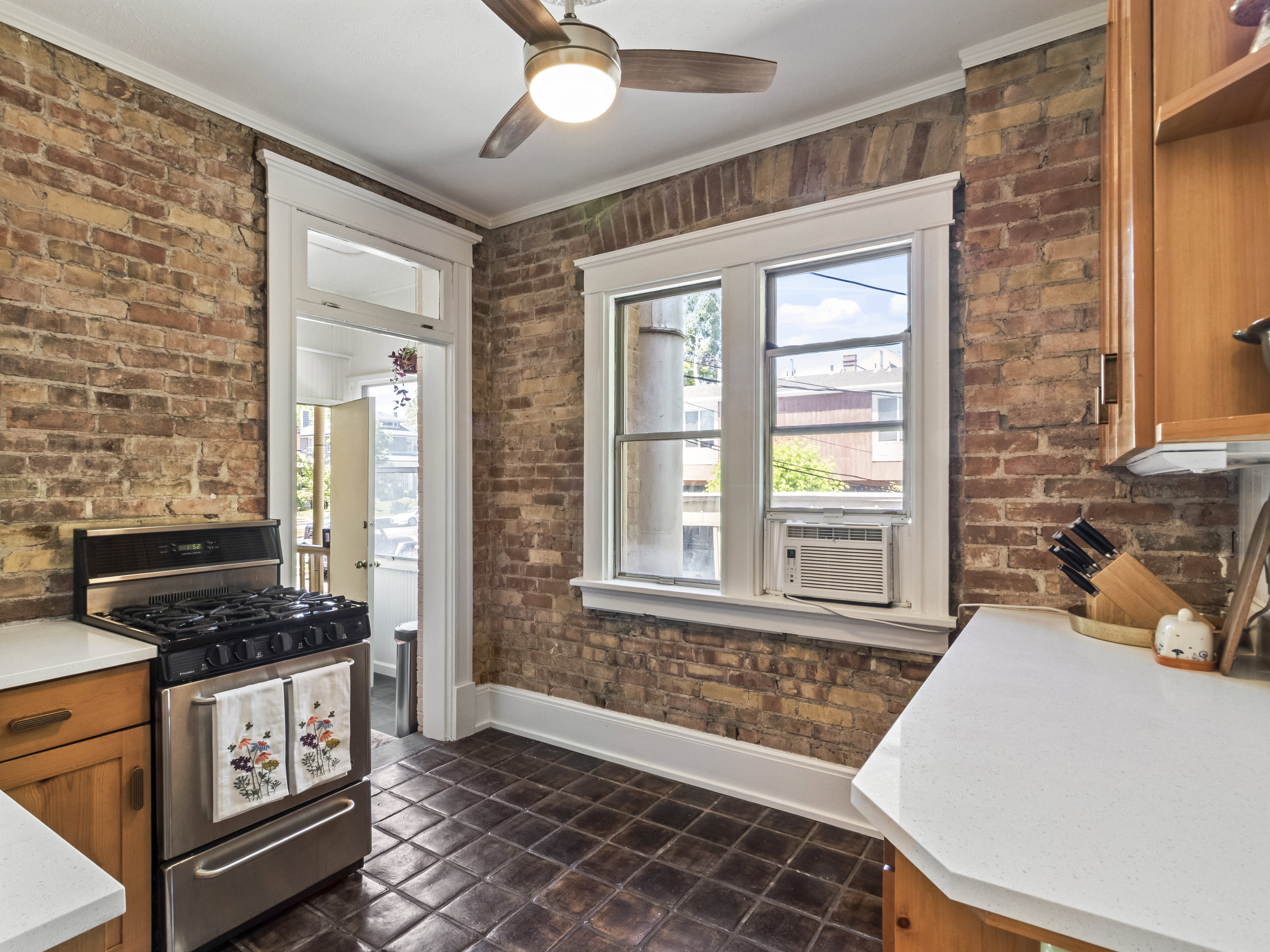 Exposed brick walls defining the space, complemented by a ceiling fan with integrated lighting