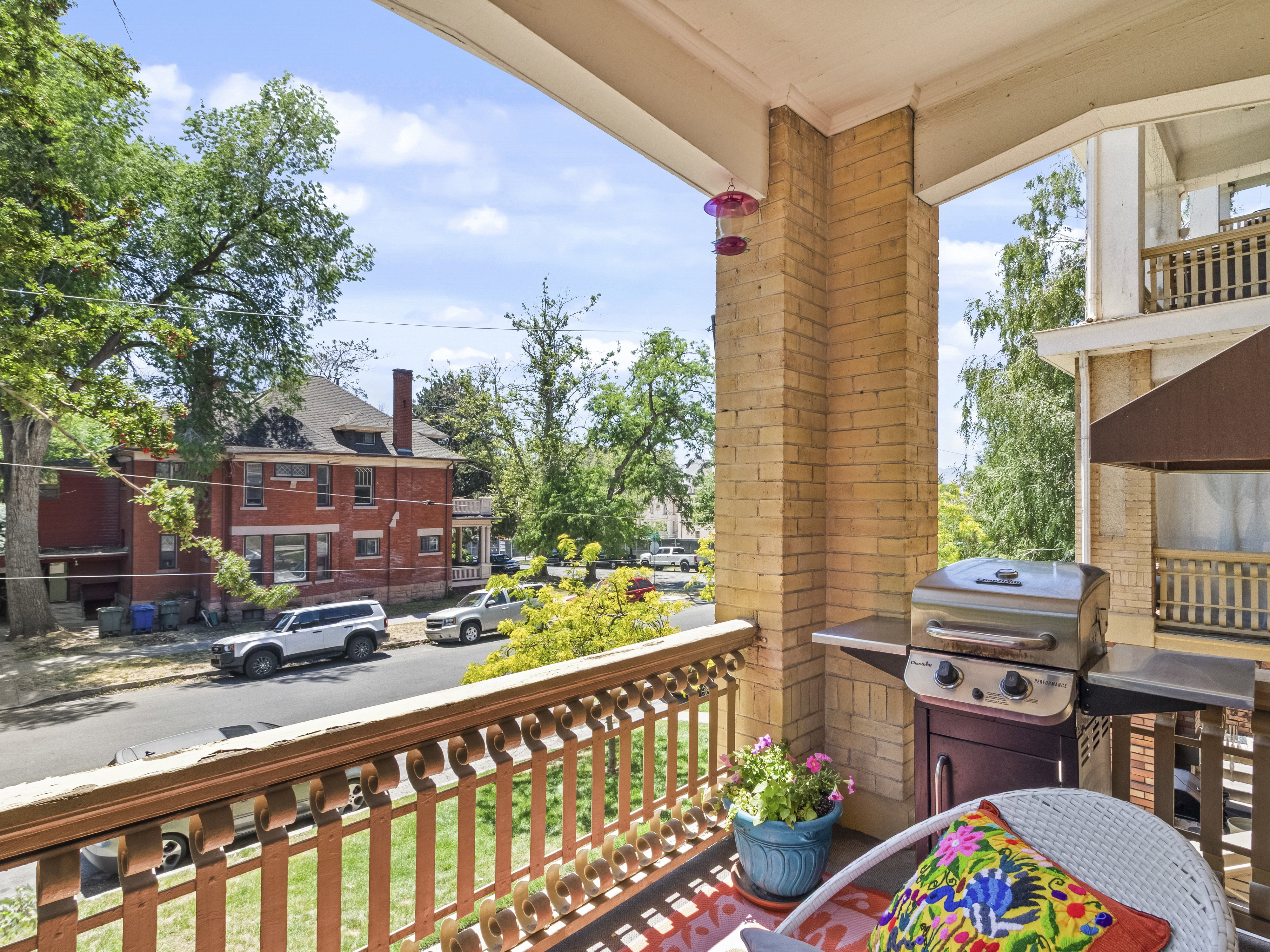 Brick-columned private balcony with a decorative wood railing