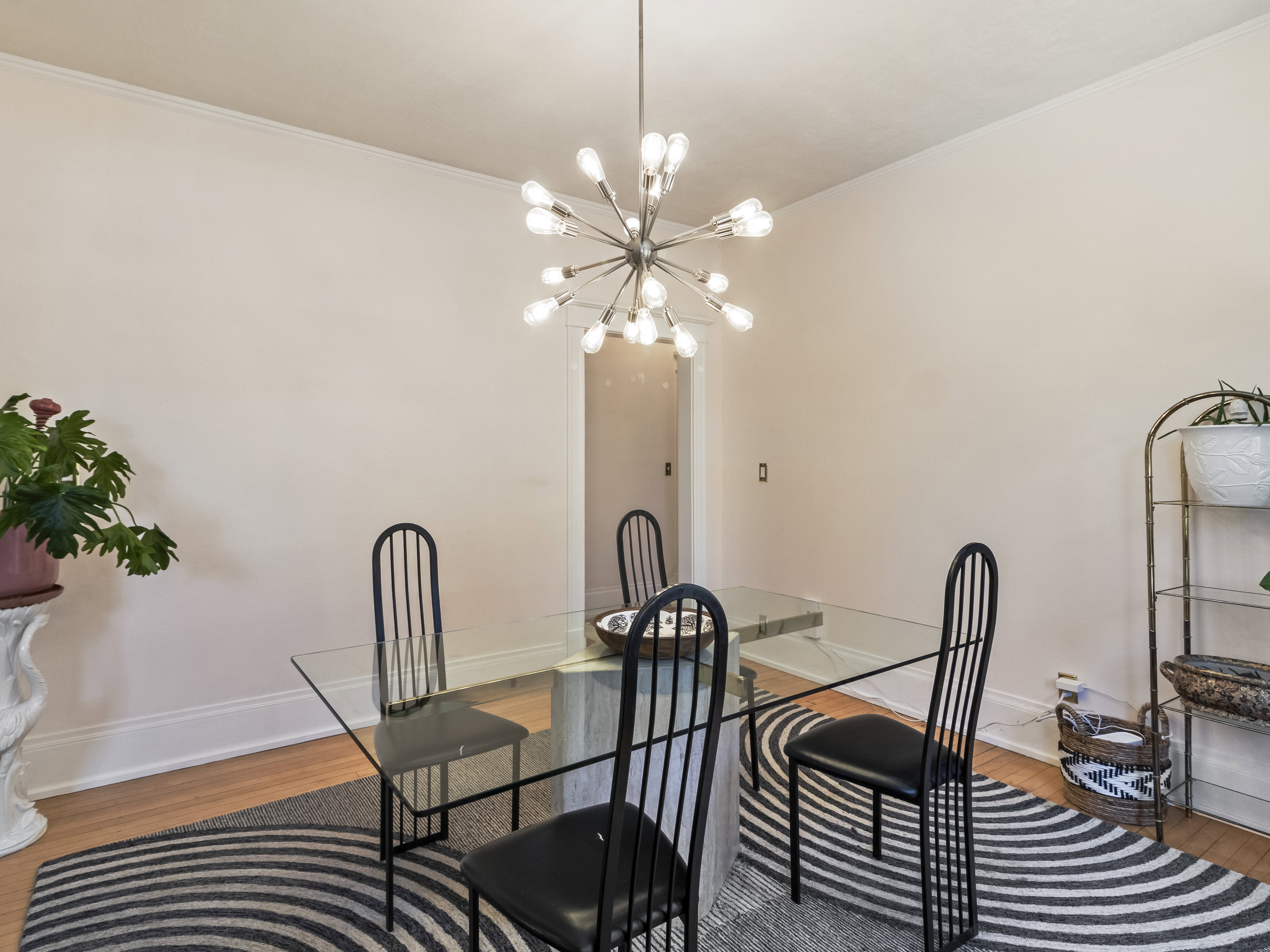 Dining area featuring a contemporary sputnik chandelier, light wood-finish flooring, and white baseboards