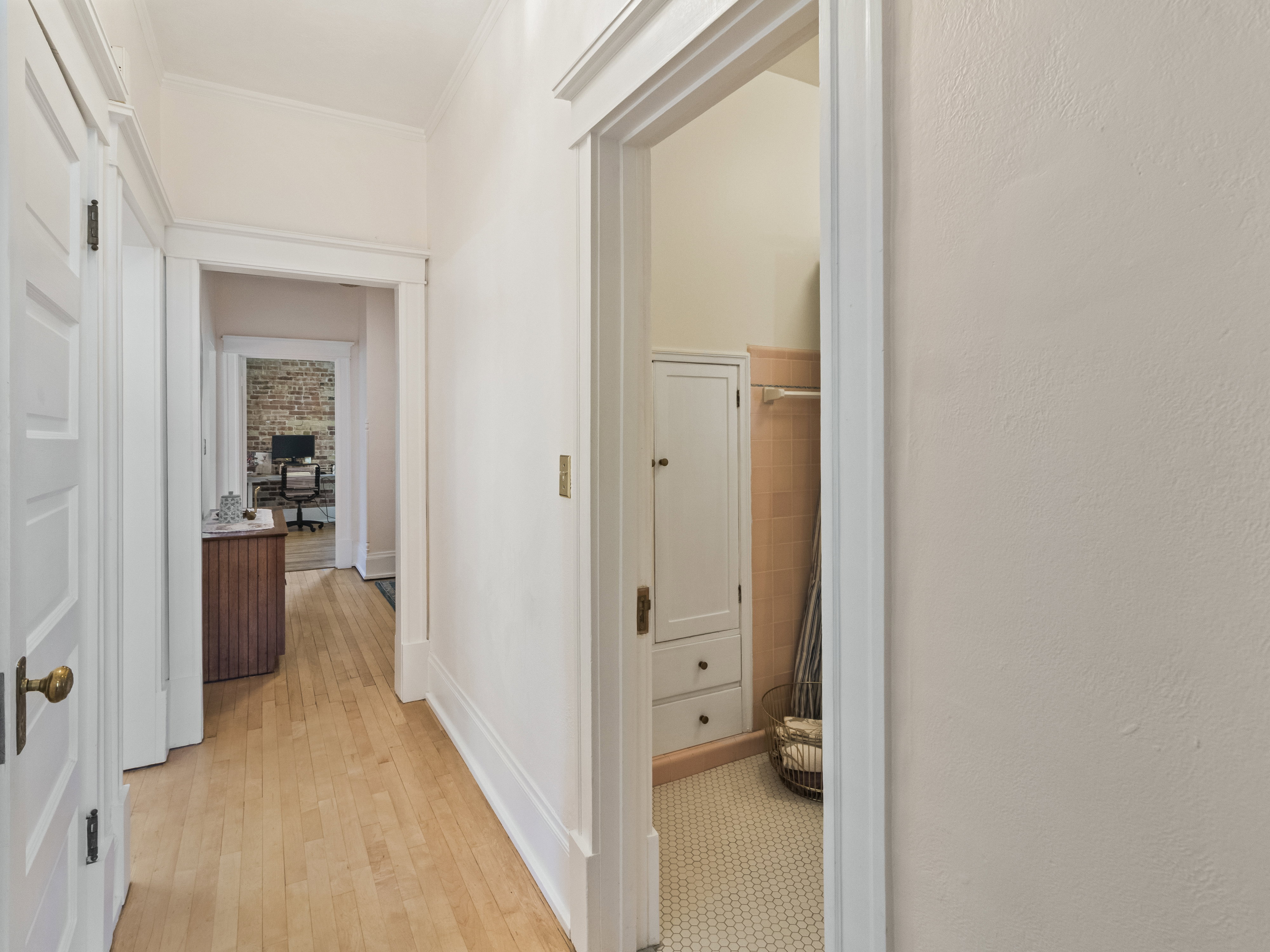 Hallway with wood-finish flooring and white trim