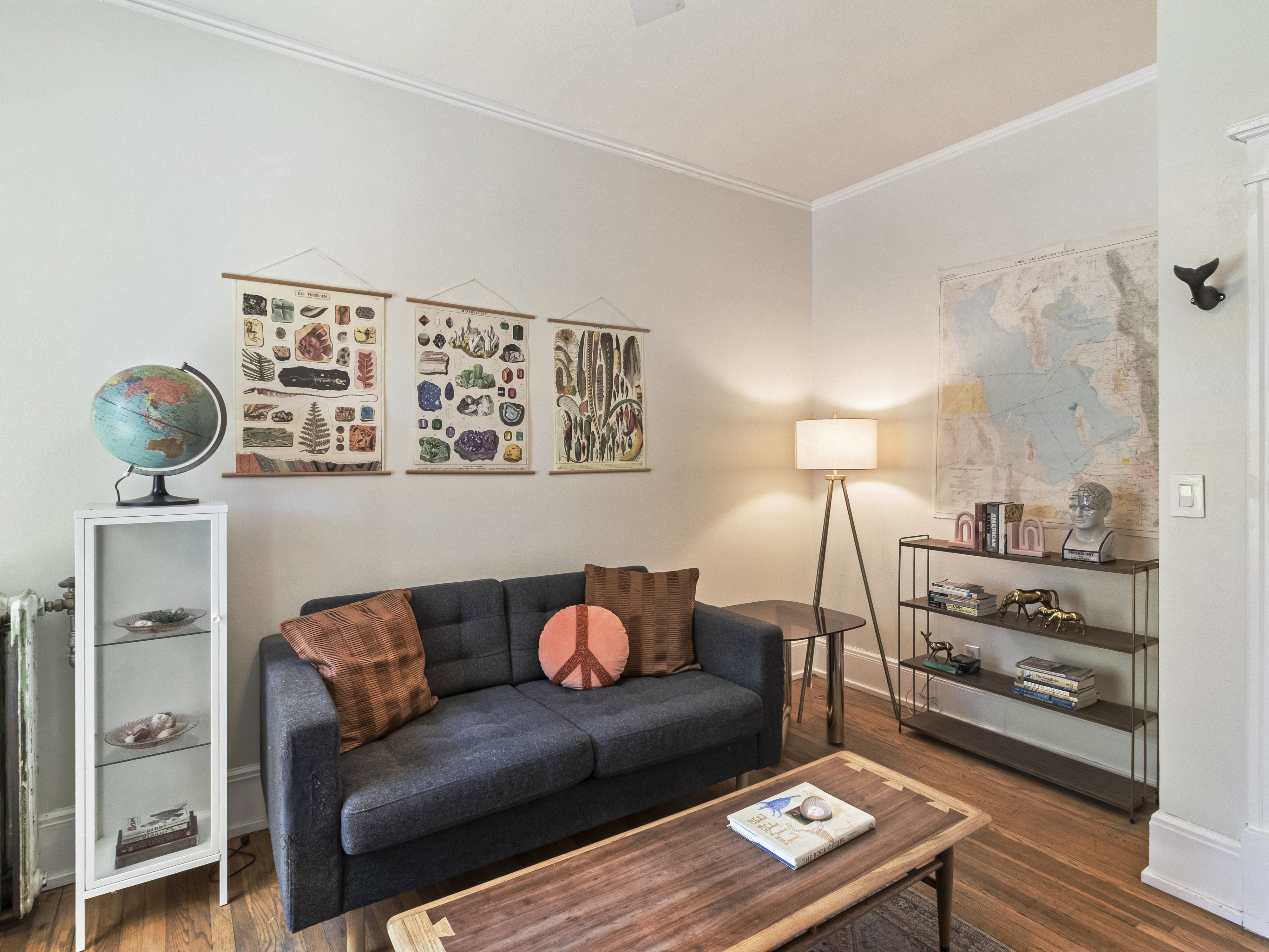 Living space featuring wood-finish flooring, white crown molding, and light-toned wall paint