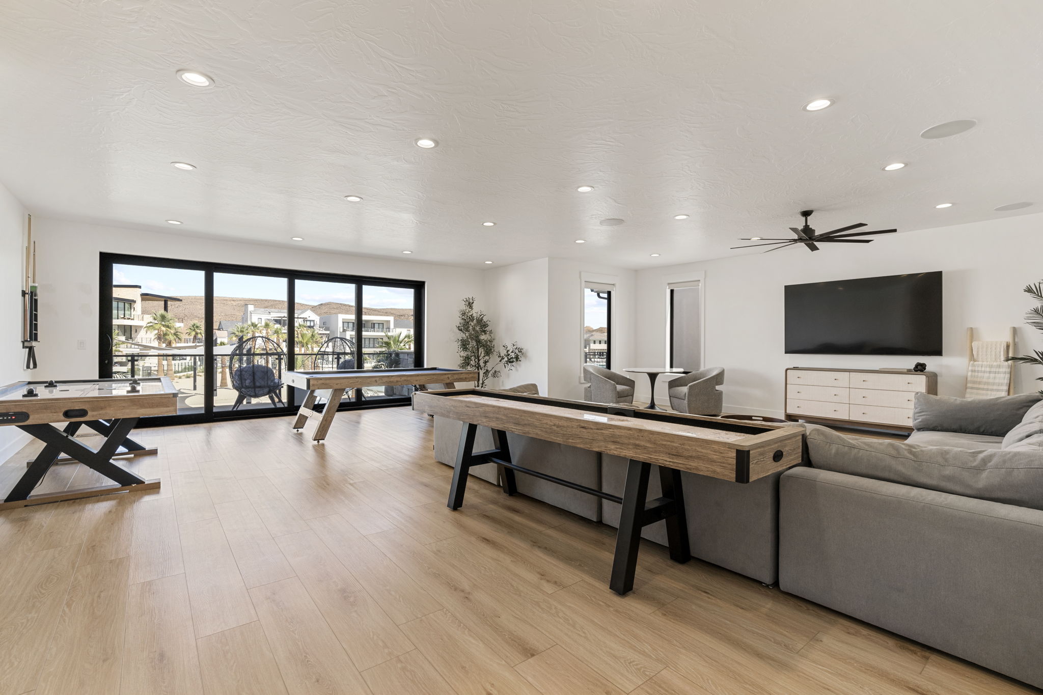 Spacious open-concept room featuring light wood-finish flooring and extensive recessed lighting