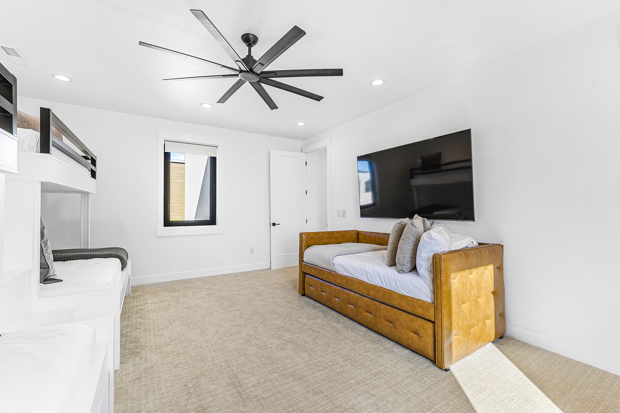 Carpeted room featuring a ceiling fan with multiple blades, recessed lighting, a built-in bunk bed structure, and a window with black trim