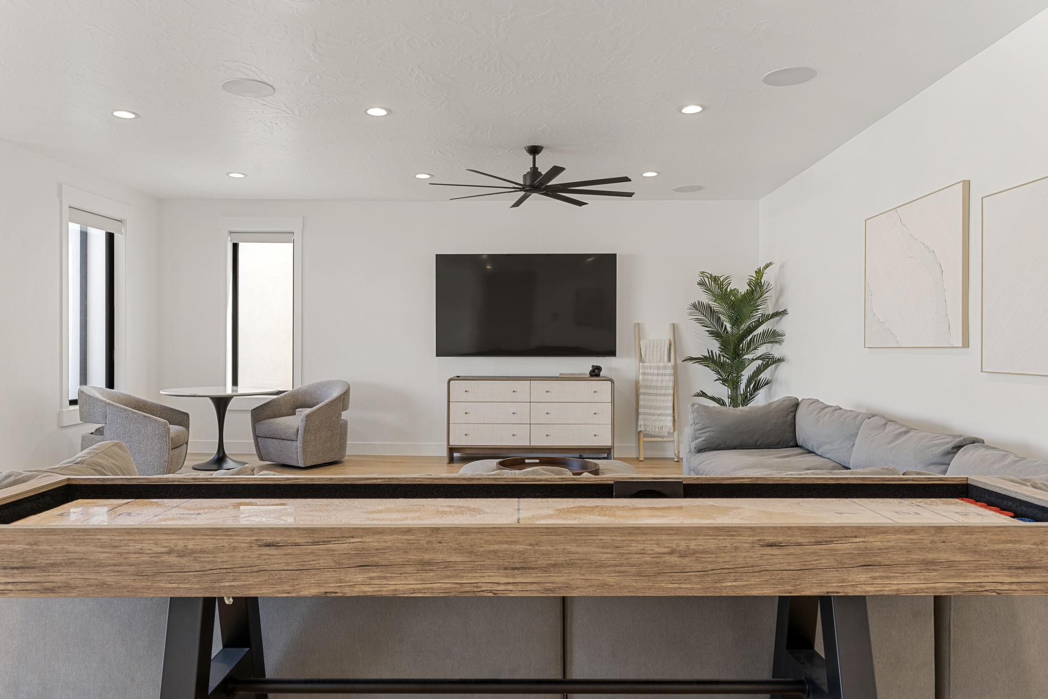 Recreation area featuring recessed lighting, a ceiling fan, wood-finish flooring, and white walls