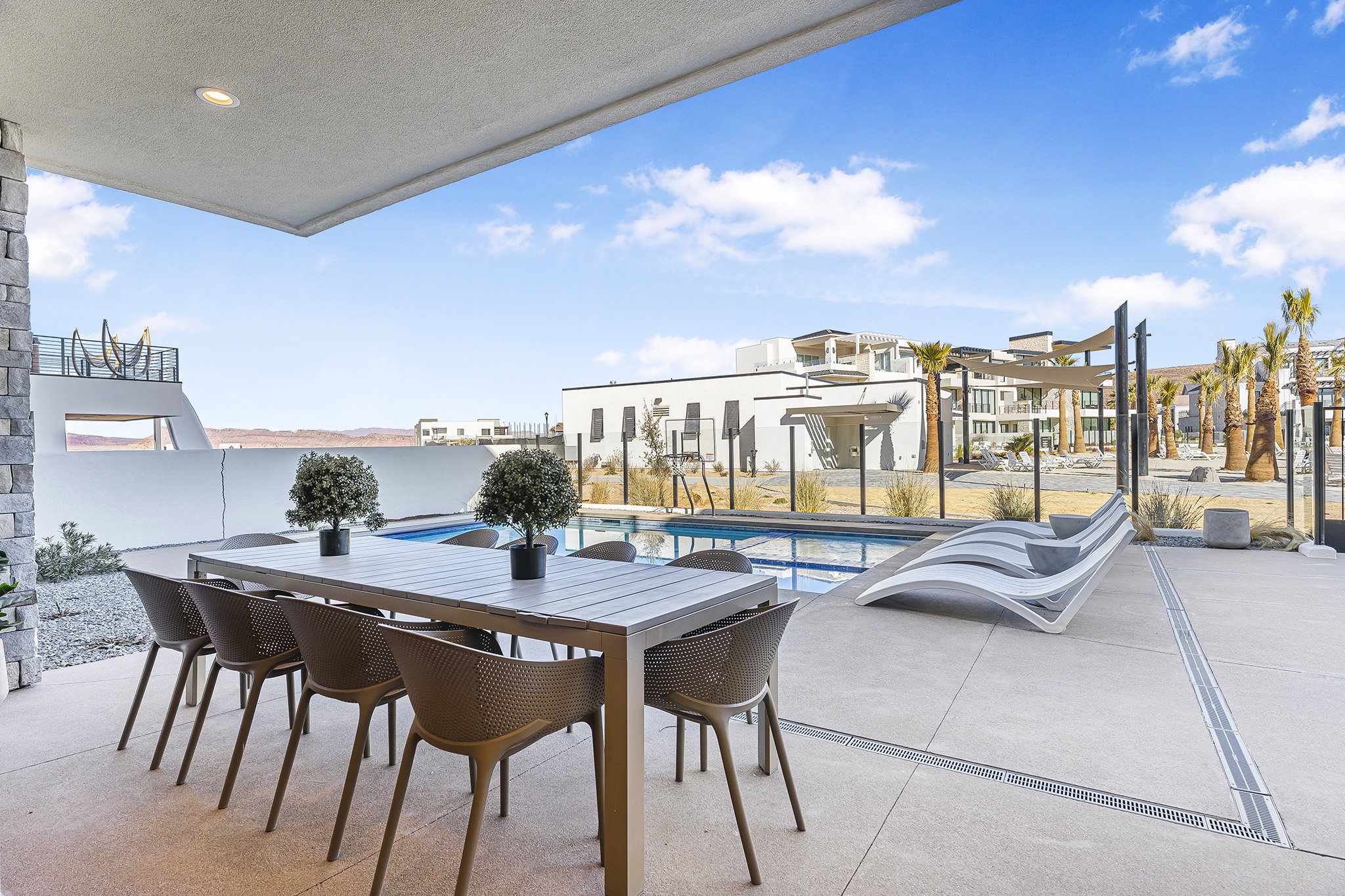 Covered patio featuring a concrete floor, stone pillar, and recessed lighting