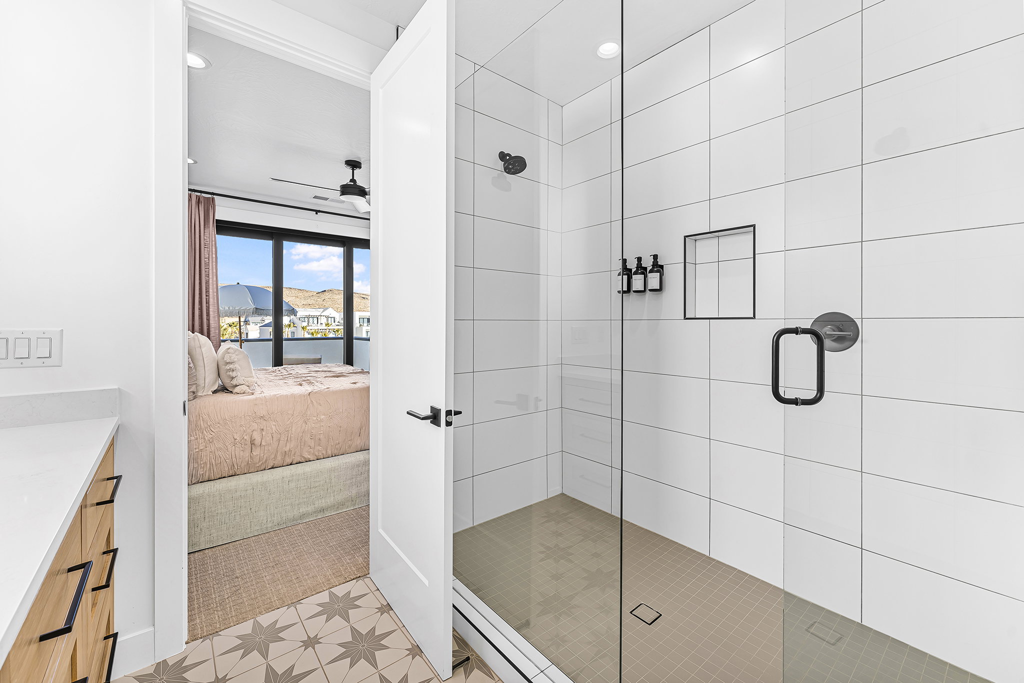 Walk-in shower featuring a glass enclosure, white subway tile surround, and matte black fixtures