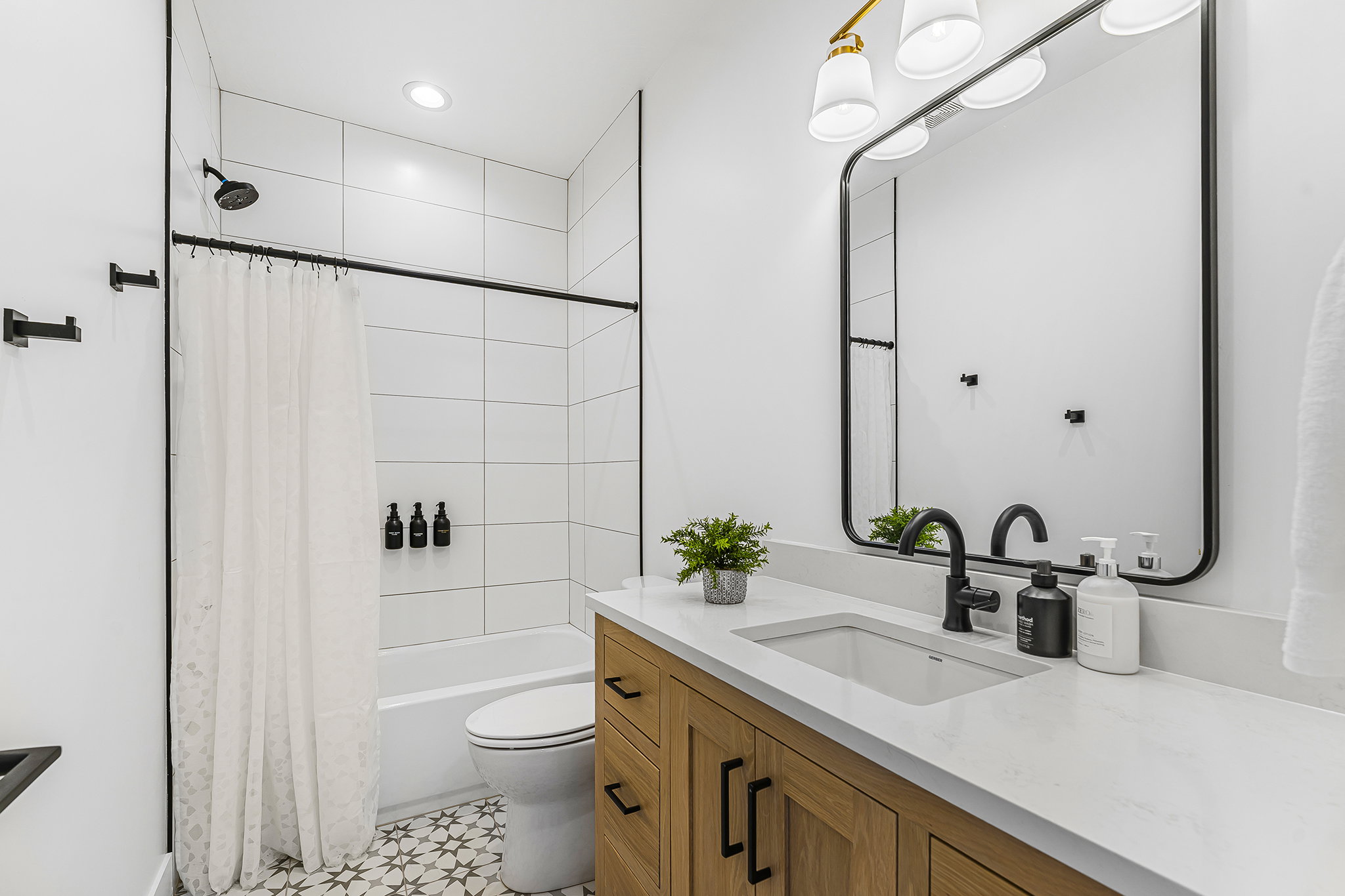 Modern bathroom featuring a wood-finish vanity with a light-colored countertop and integrated sink