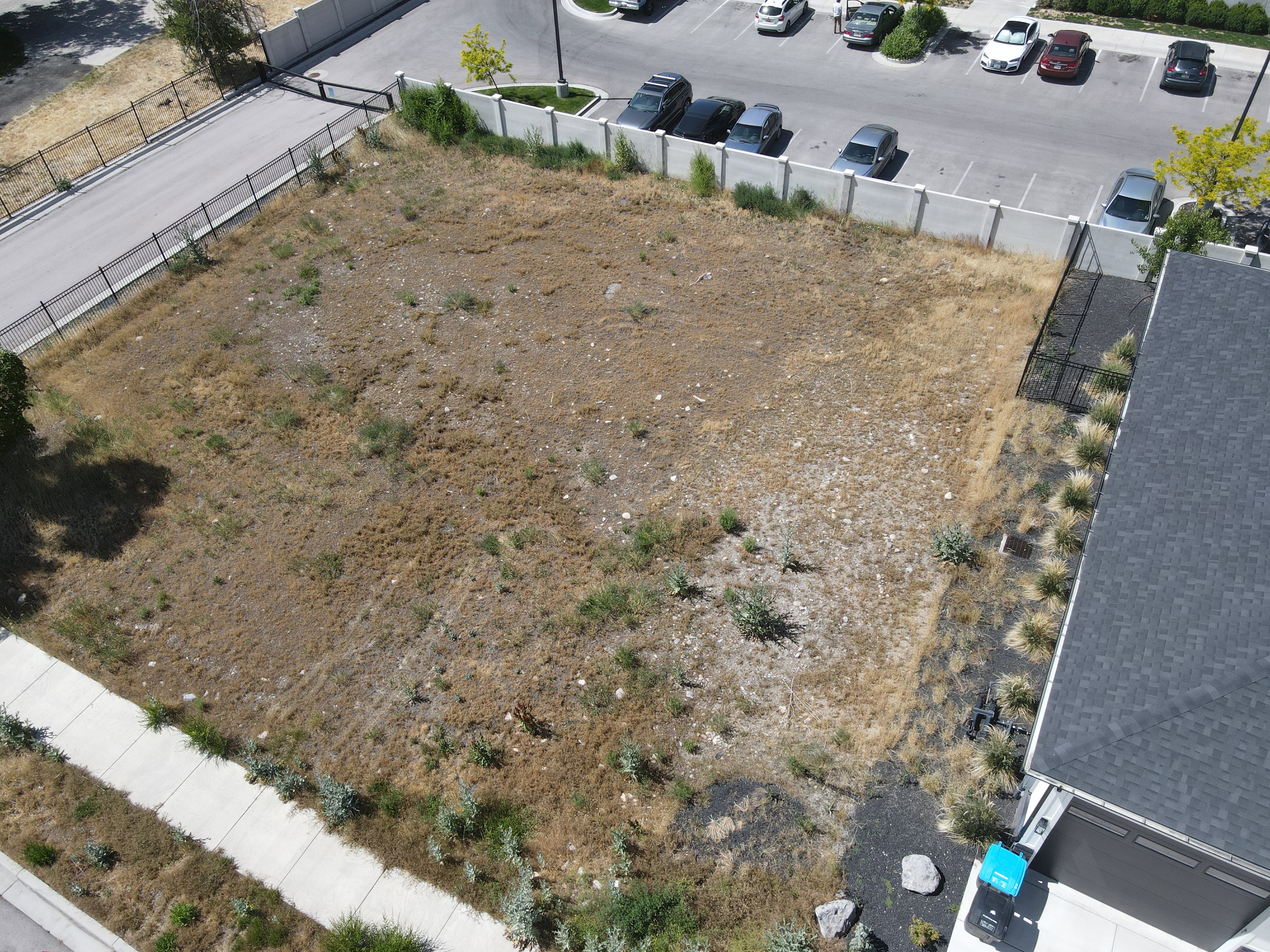 Expansive undeveloped lot featuring perimeter fencing on three sides