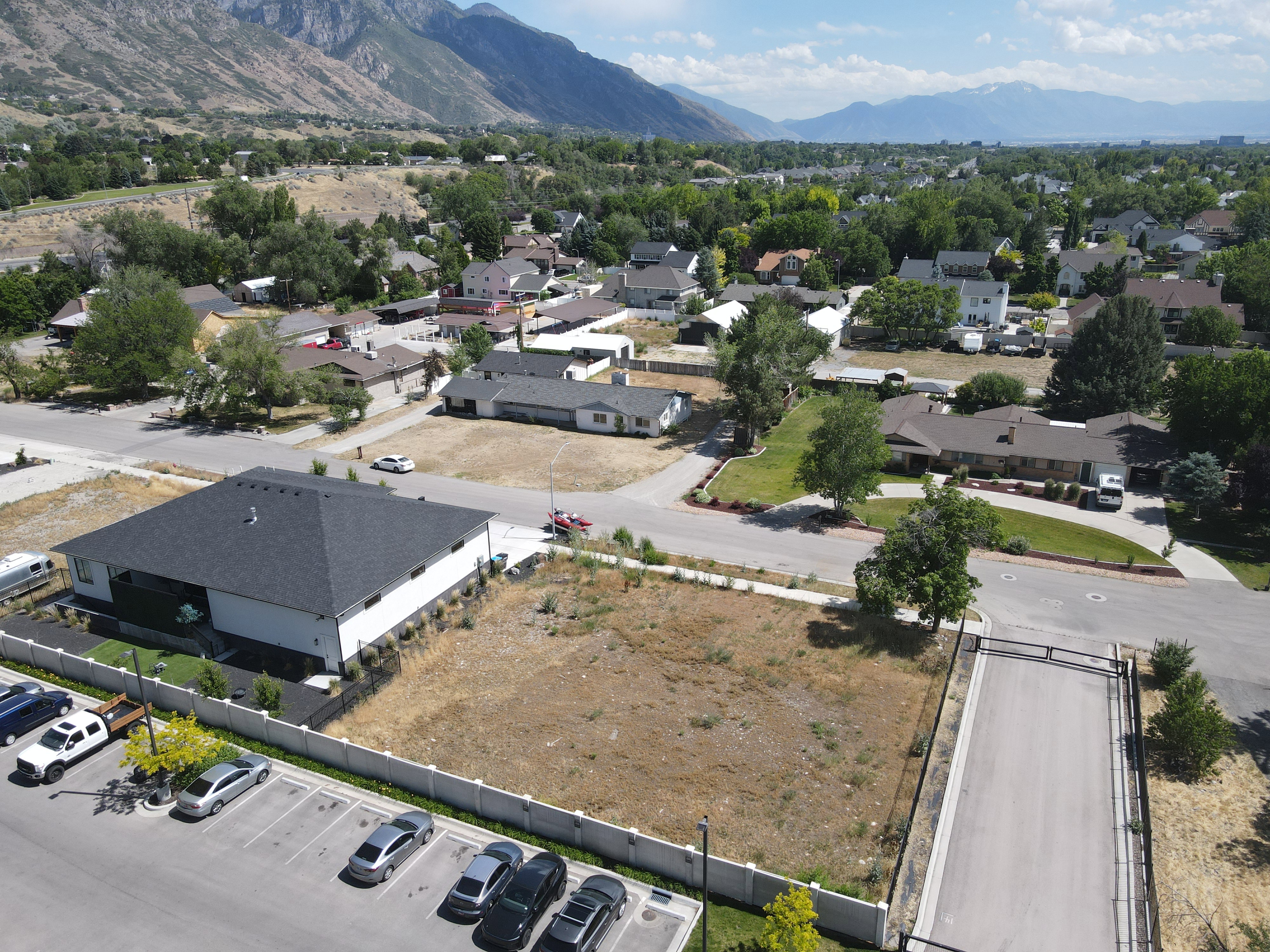 Expansive land parcel featuring clear ground, a surrounding fence, and a paved road access
