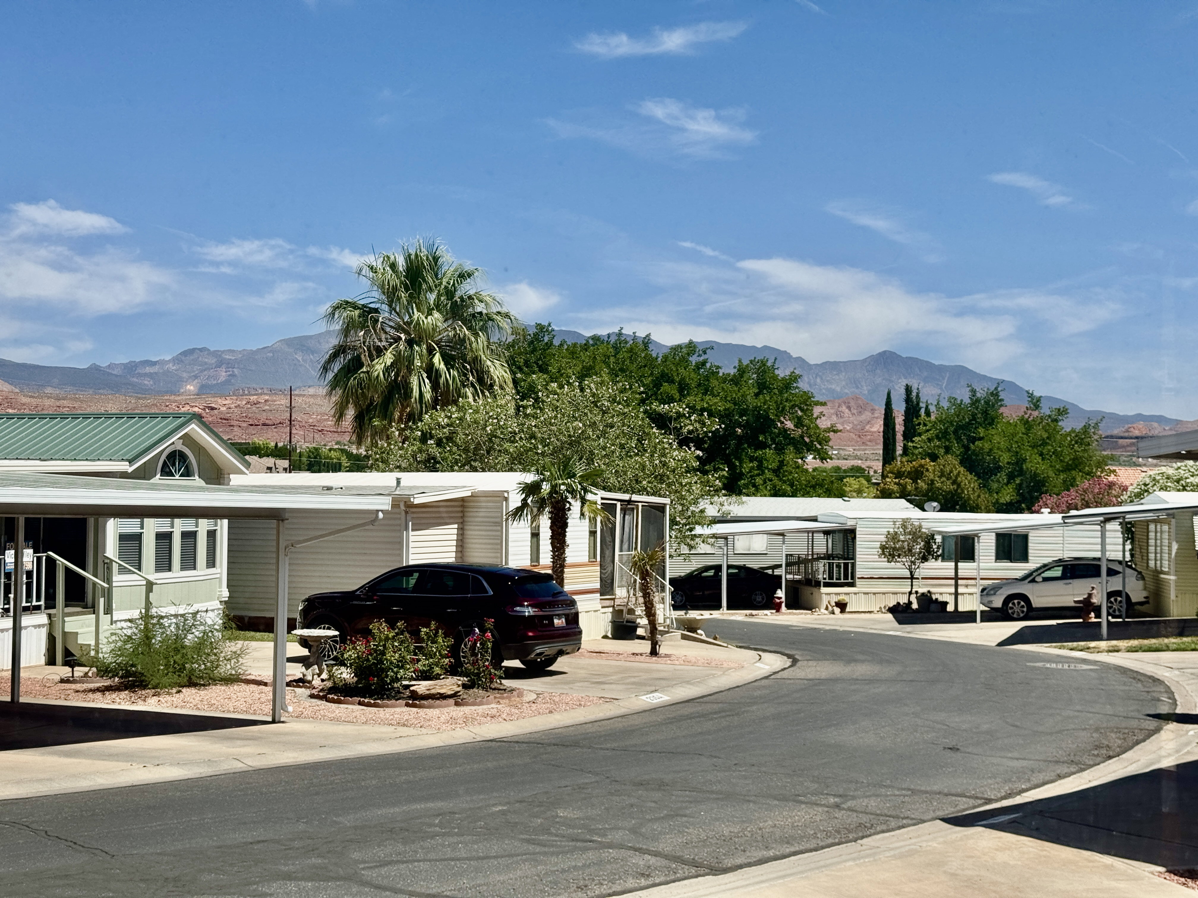 Residential street with homes featuring covered parking and mountain backdrop