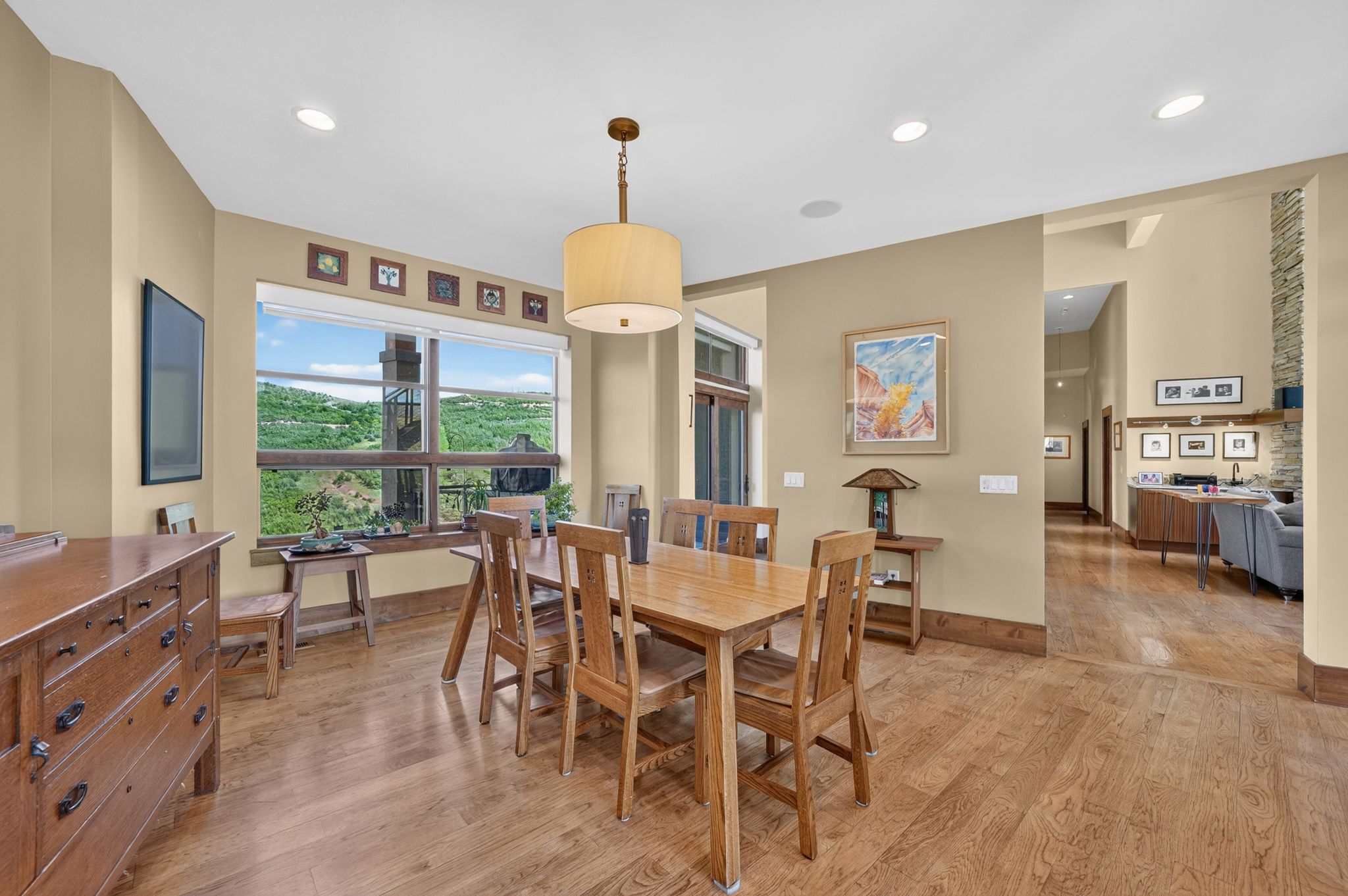 Spacious dining area featuring wood-finish flooring, recessed lighting, and a drum pendant light fixture