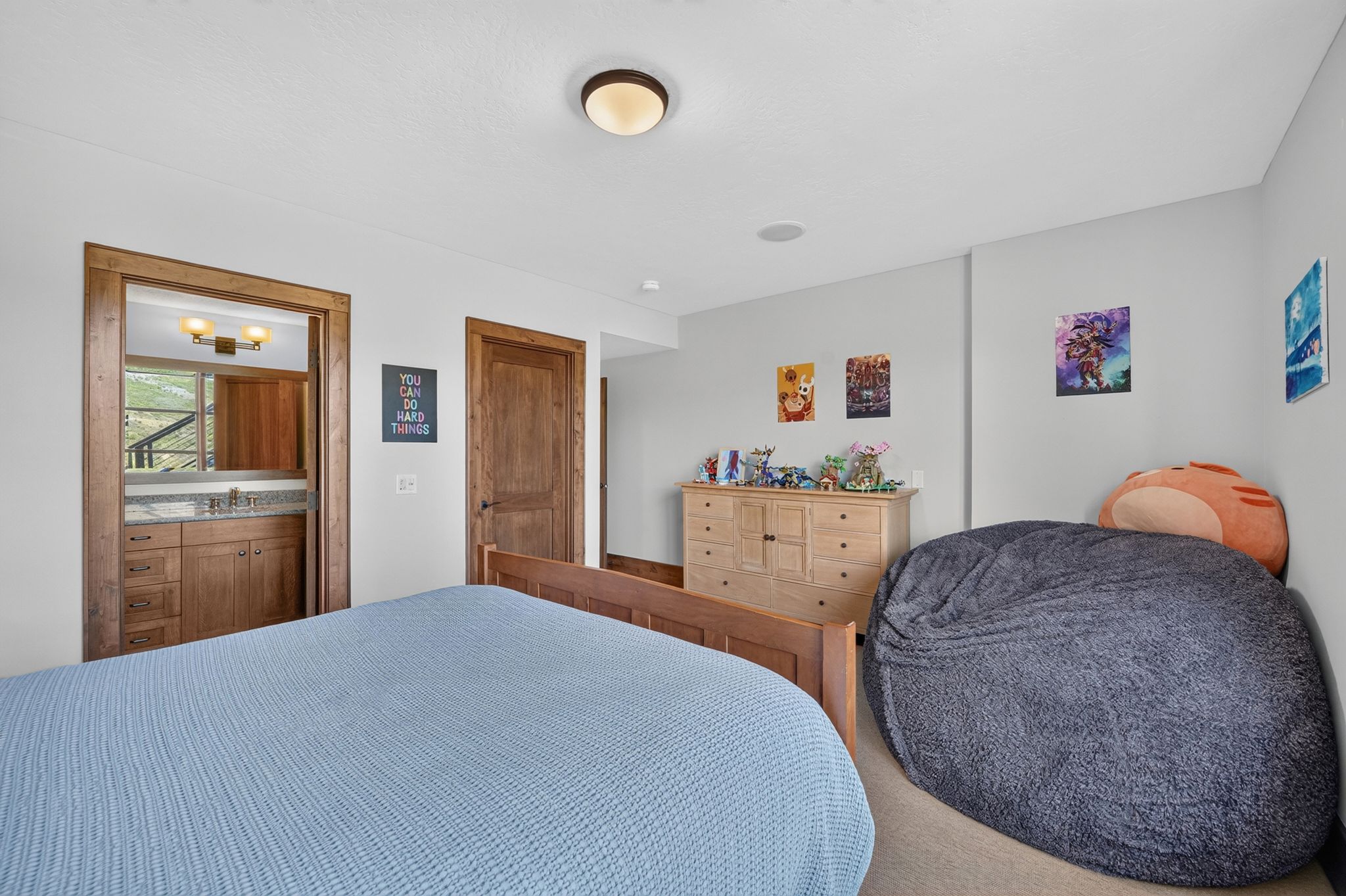 Bedroom featuring an attached bathroom vanity with a granite countertop and wood cabinetry