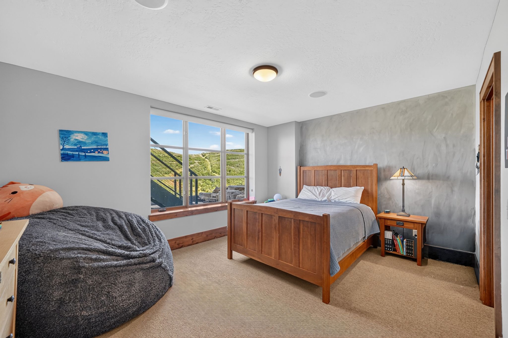 Bedroom featuring large picture windows, light gray walls, textured accent wall, recessed ceiling lighting, and carpet flooring