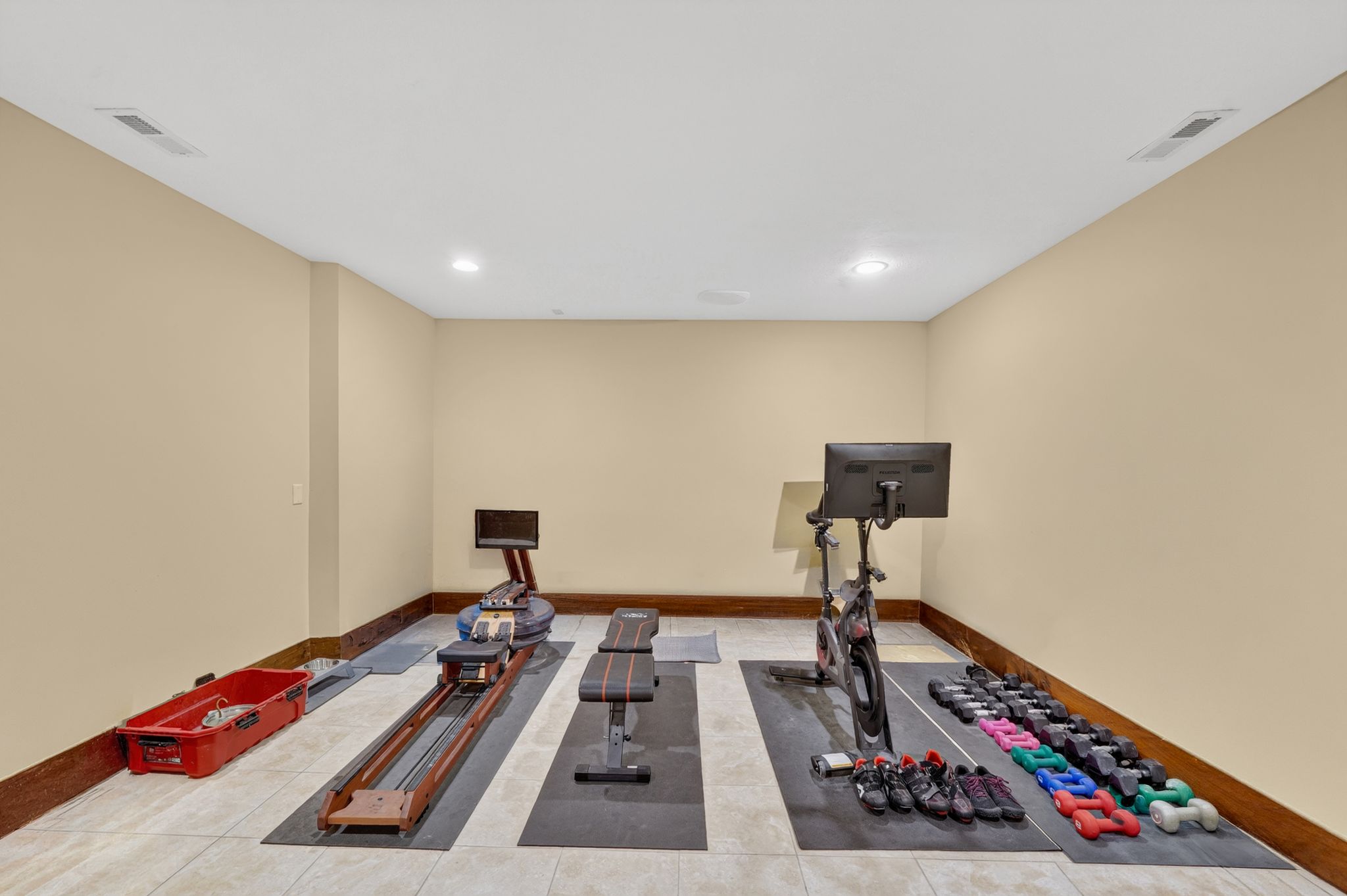 Dedicated fitness space featuring light-toned walls, recessed lighting, and a tiled floor