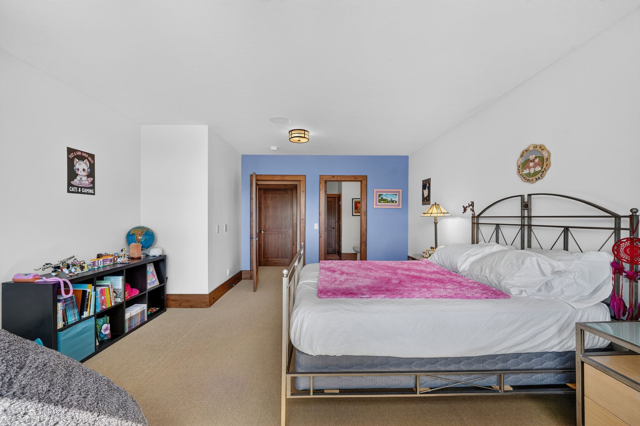 Carpeted room featuring white walls, a single accent wall, and a tray ceiling with a flush-mount light fixture