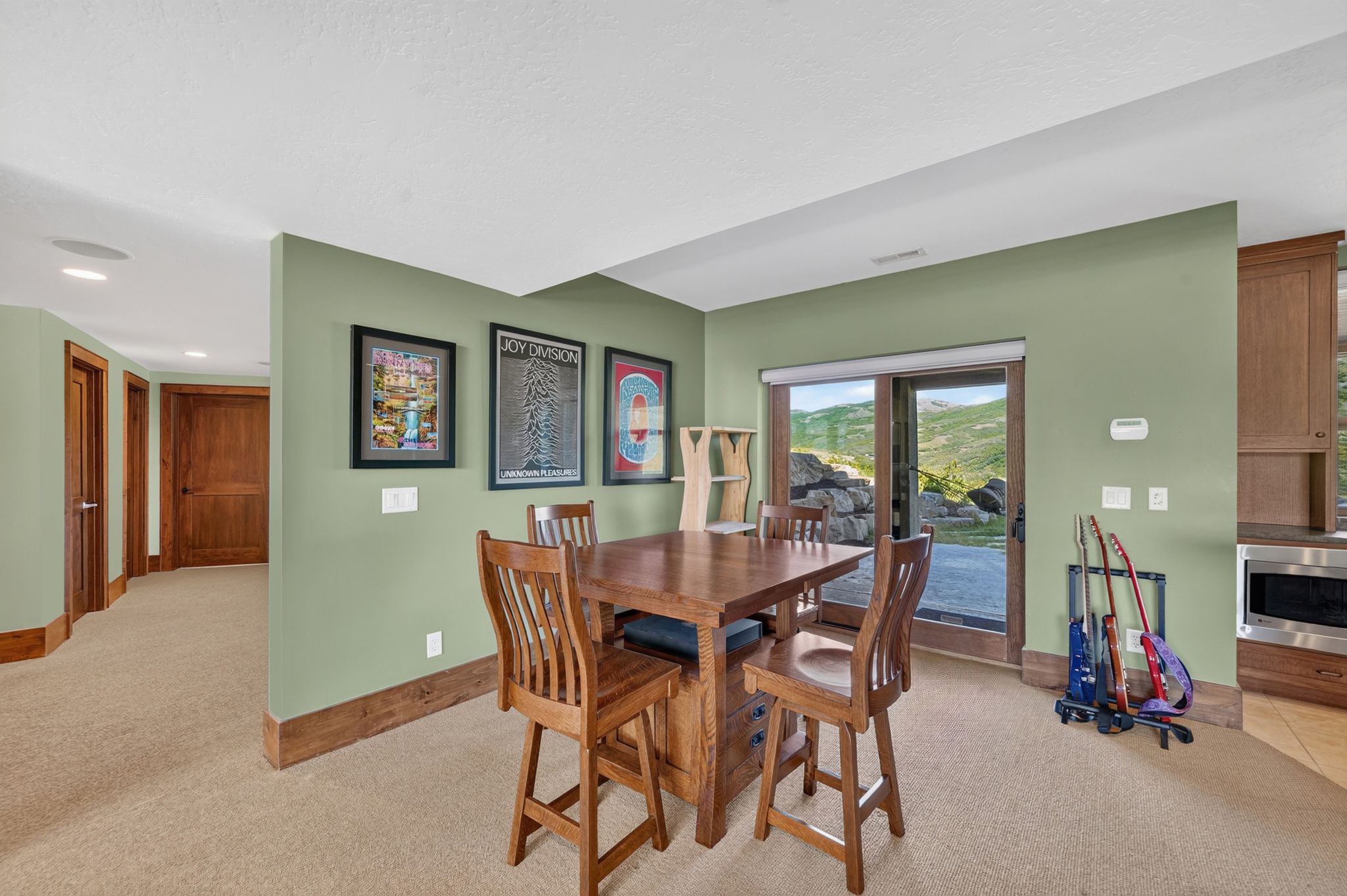 Carpeted recreation area with a sliding glass door offering outdoor access