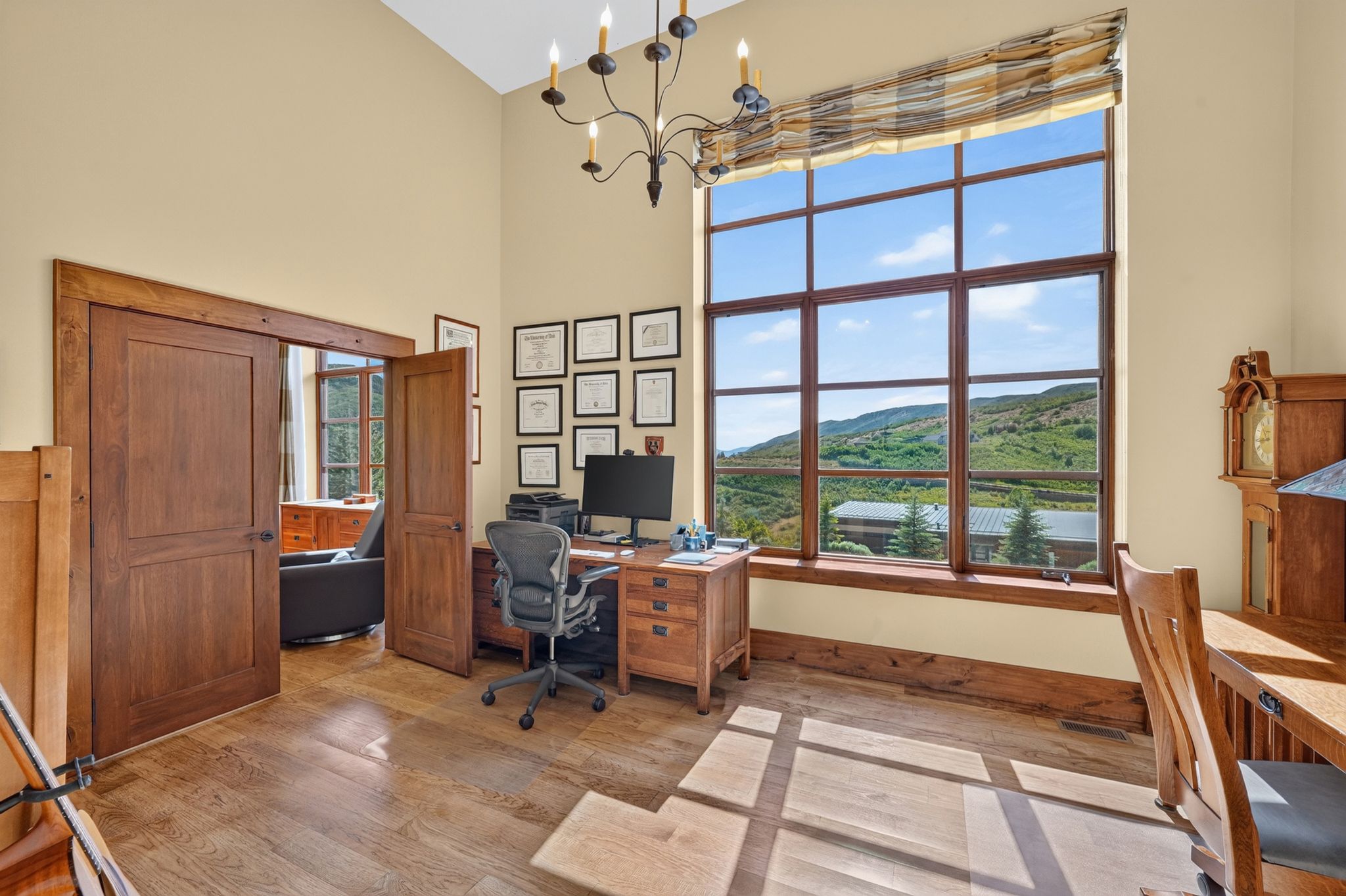 Room featuring a large grid-pane window with a mountain landscape