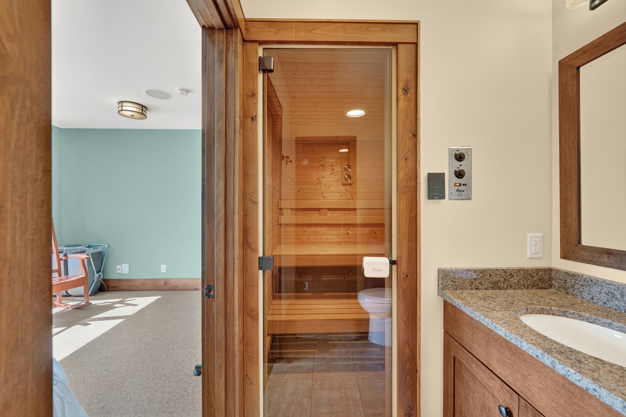 Custom sauna featuring clear glass door and light wood paneling