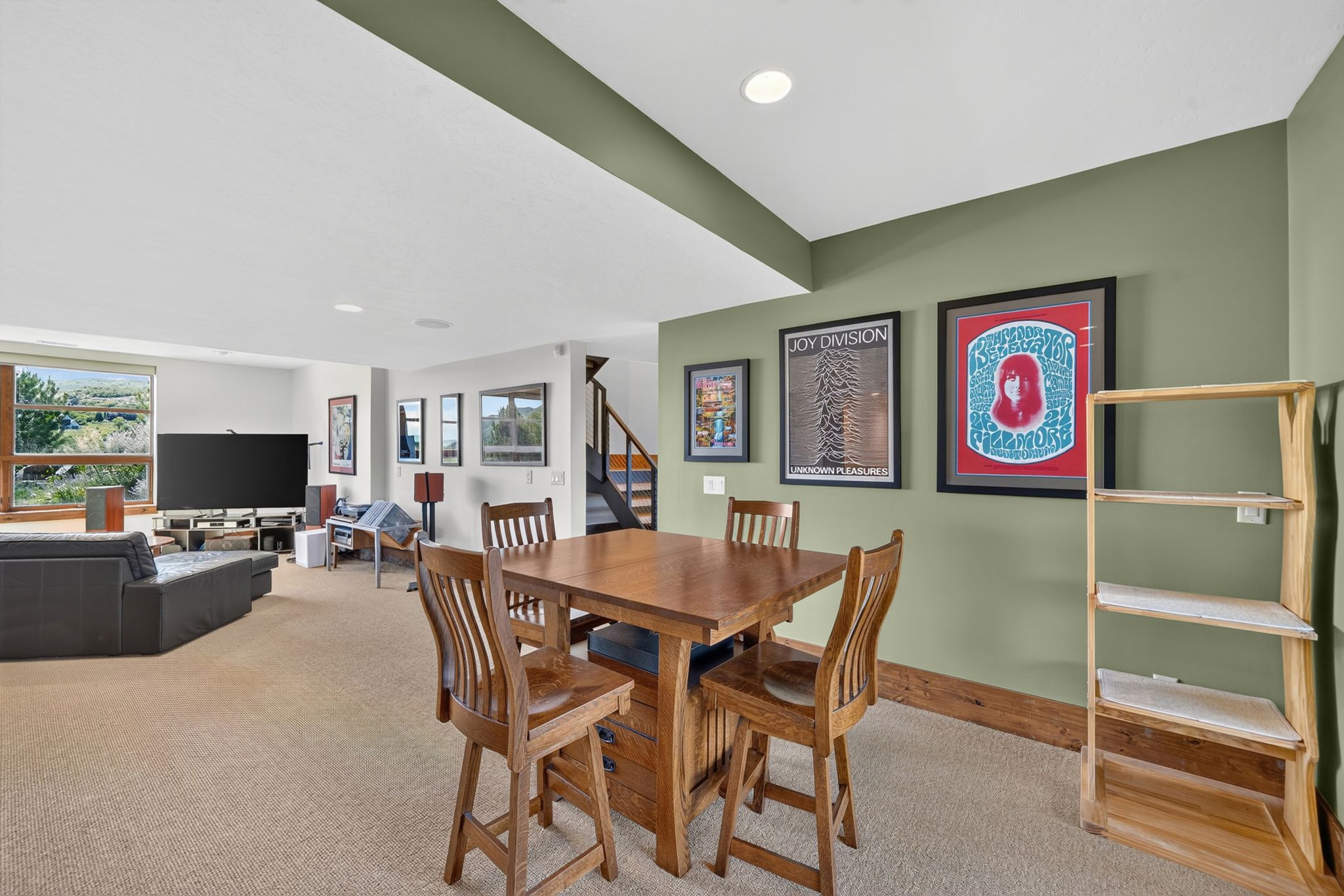 Spacious recreation room featuring neutral carpeting, recessed ceiling lighting, and a prominent window with exterior views