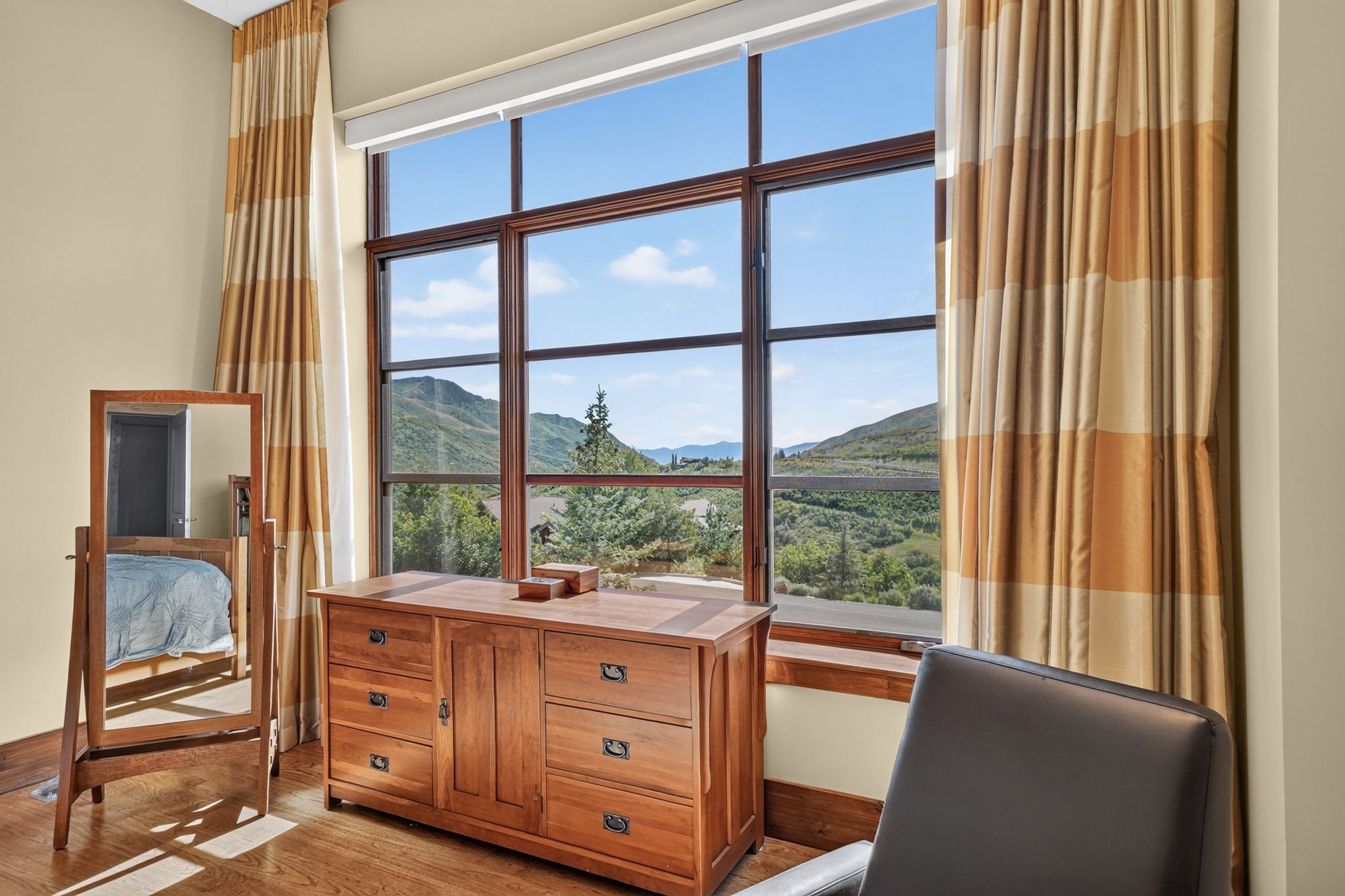 Expansive window with dark wood framing, providing abundant natural light and showcasing the surrounding mountainous landscape