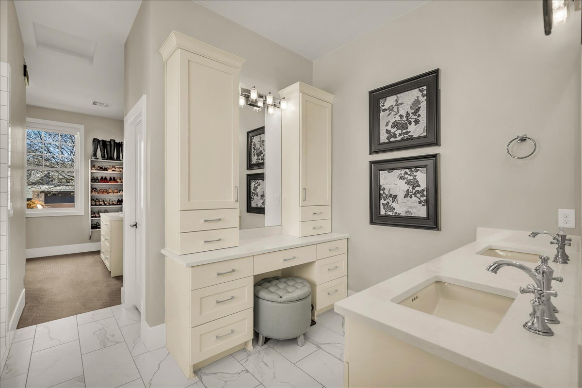 Bathroom featuring white tile flooring and dual vanity