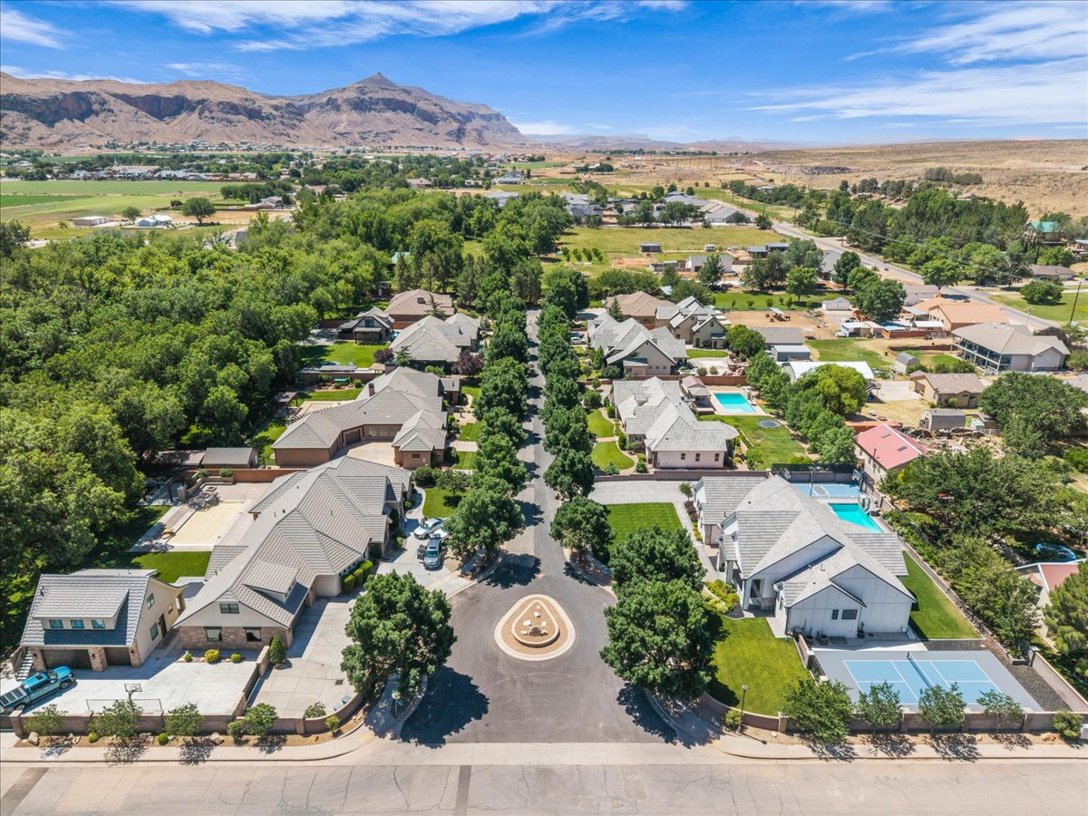 Aerial perspective of a residential cul-de-sac with mature trees and a central landscaped roundabout