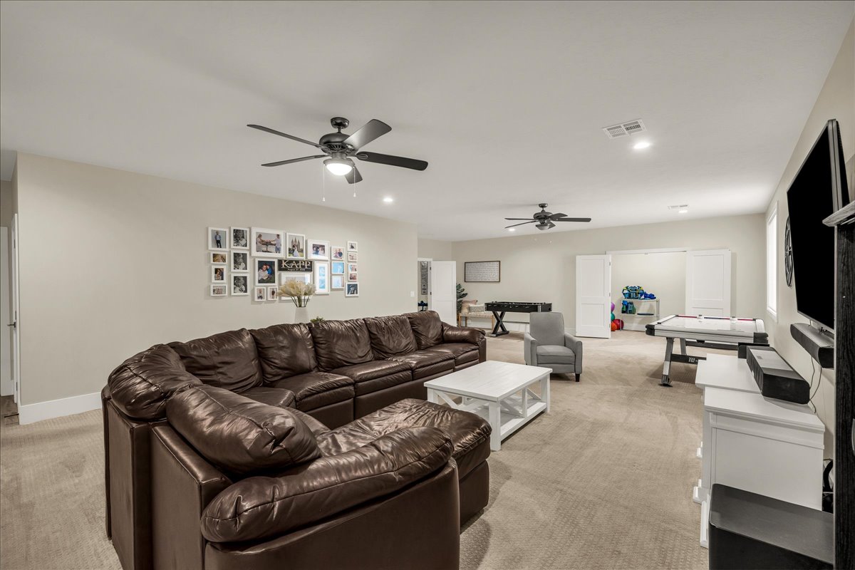 Spacious bonus room featuring neutral carpeting, recessed lighting, and dual ceiling fans