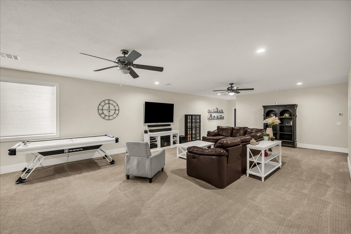 Spacious recreational room featuring recessed lighting and two ceiling fans