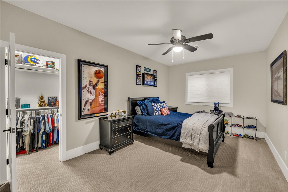 Bedroom with neutral wall color, carpet flooring, a window with blinds, and a ceiling fan