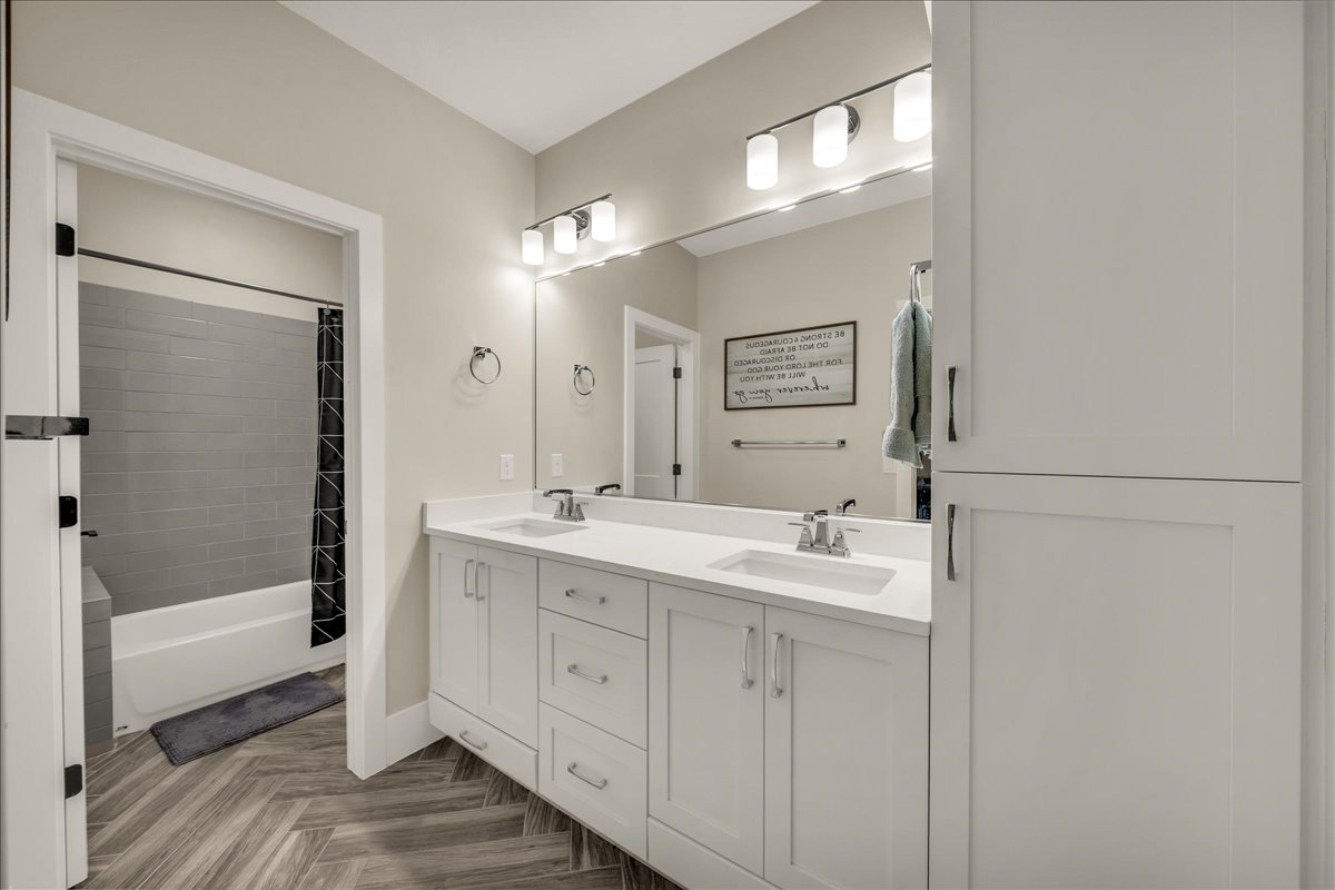 Double vanity with white cabinetry, quartz countertops, and dual undermount sinks