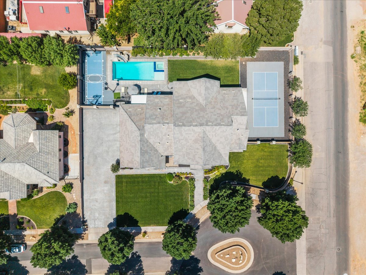 Expansive property featuring a multi-sport court, a dedicated tennis court, a swimming pool, mature landscaping, and a substantial paved driveway