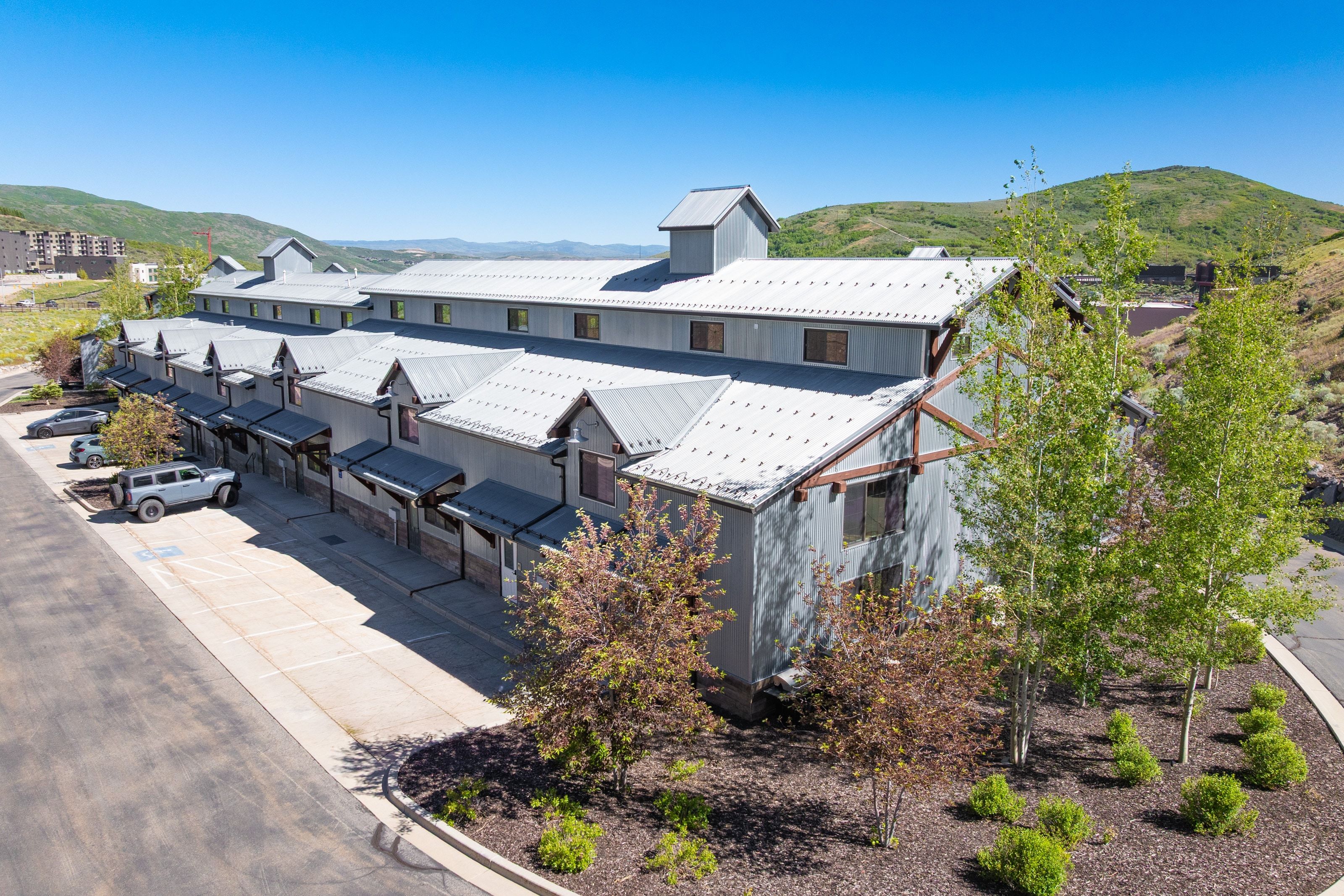 Multi-unit property featuring a contemporary design with gray siding and multiple dormer windows