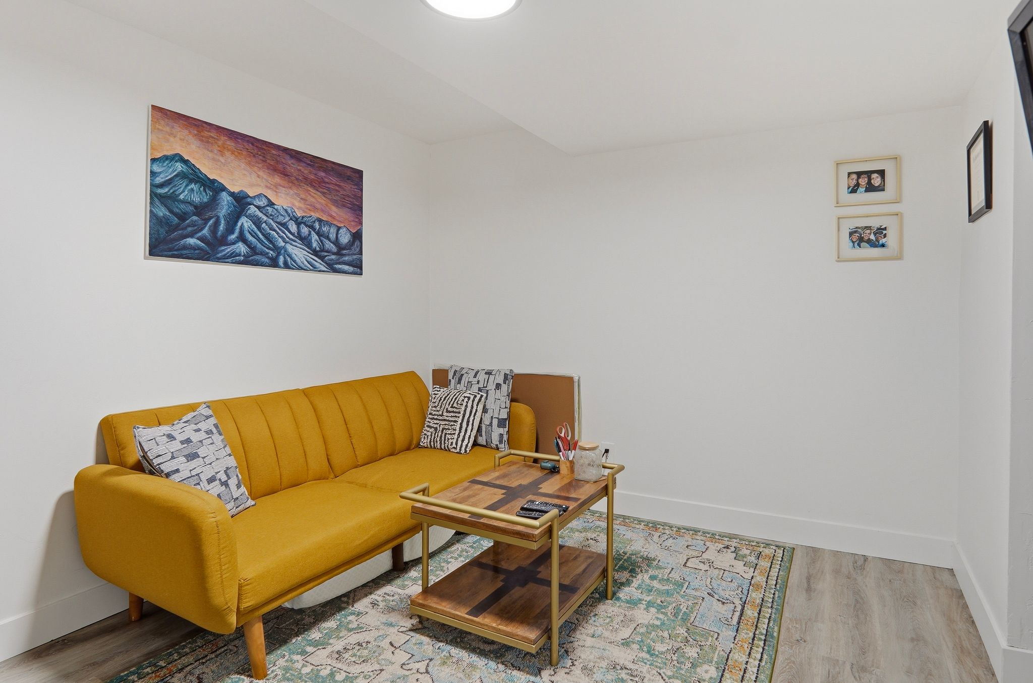 Recessed lighting illuminates this room featuring light wood-finish flooring, white baseboards, and white walls