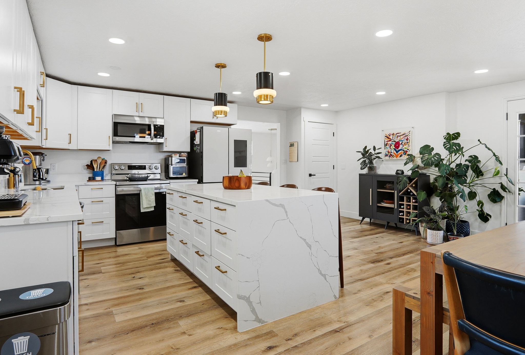 Open-concept kitchen with a large waterfall island featuring quartz-finish countertops and integrated storage