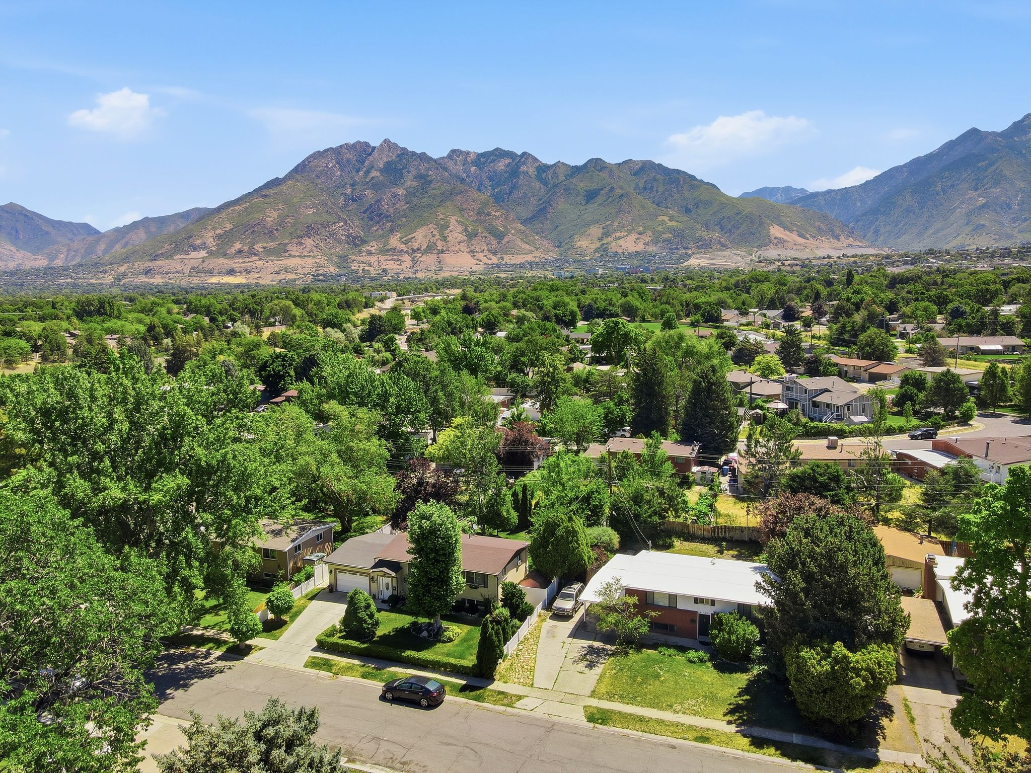 Aerial perspective showcasing a residential neighborhood with a backdrop of mountains