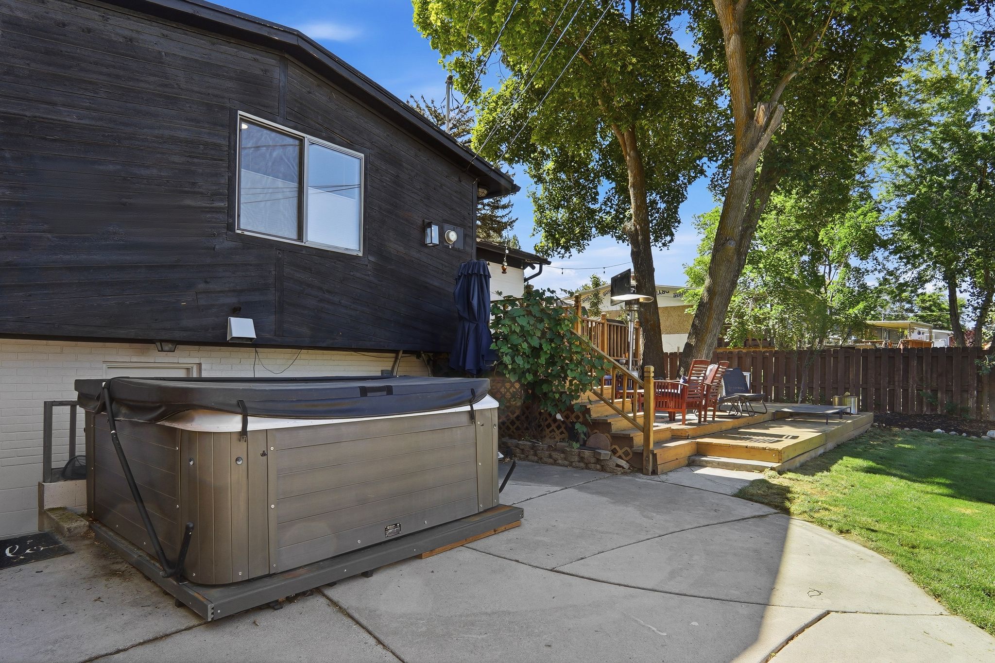 Rear exterior featuring dark horizontal siding, white brick foundation, and a dual-pane window