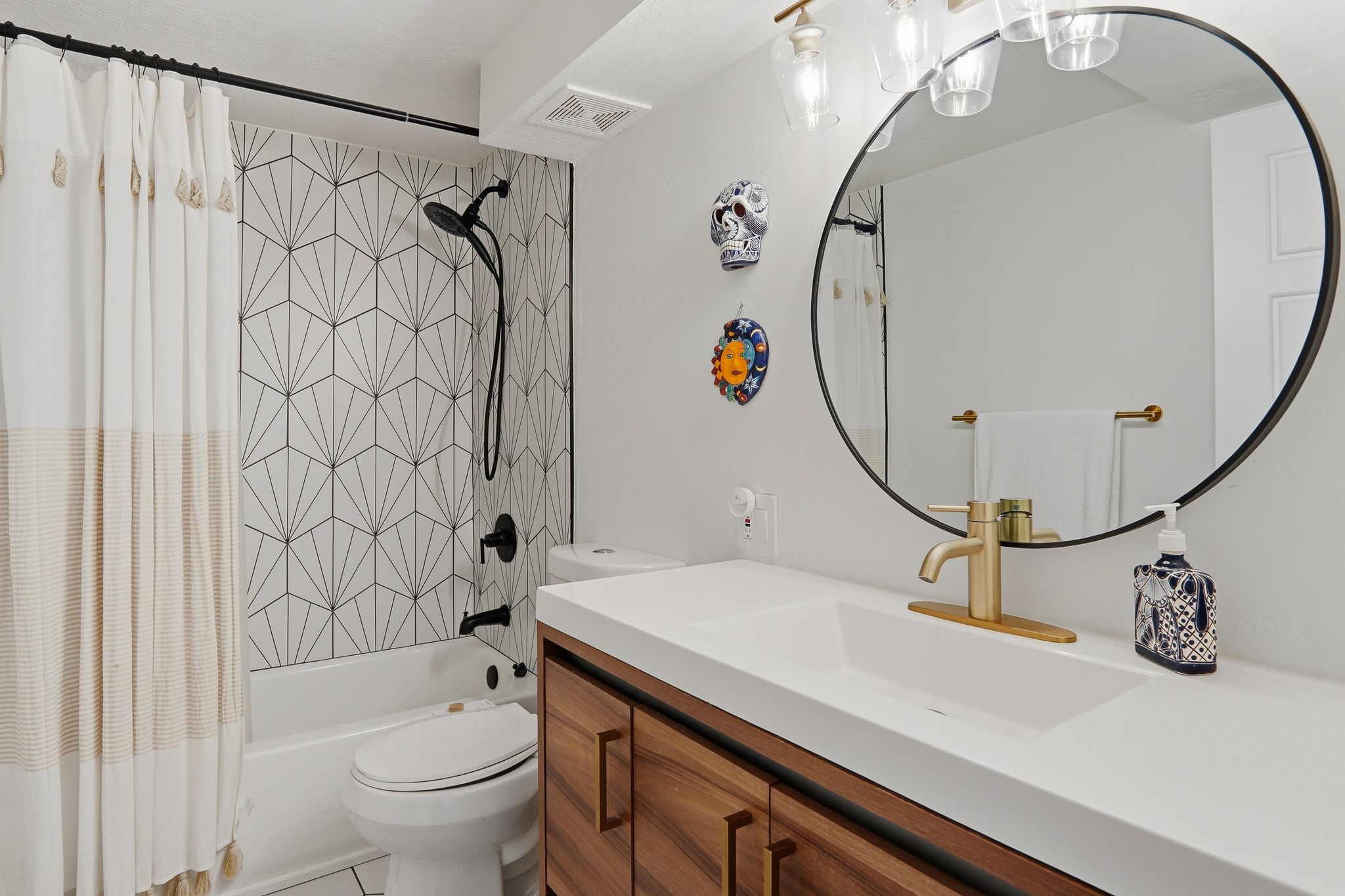 Bathroom featuring a white bathtub with geometric patterned tile surround and matte black fixtures