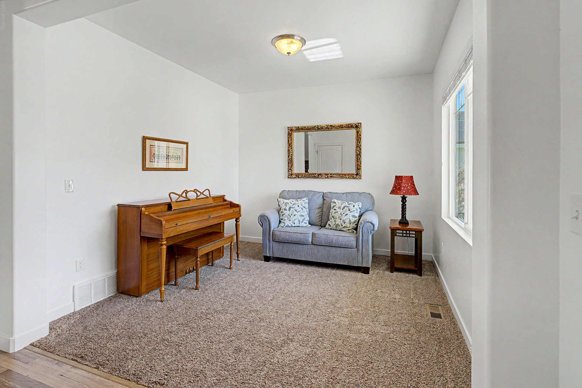 Carpeted room with white walls, a single window, and a flush-mount ceiling light fixture