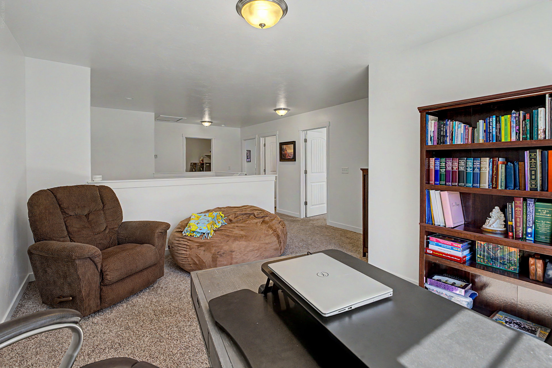 Upper-level landing featuring carpet flooring and a built-in bookshelf