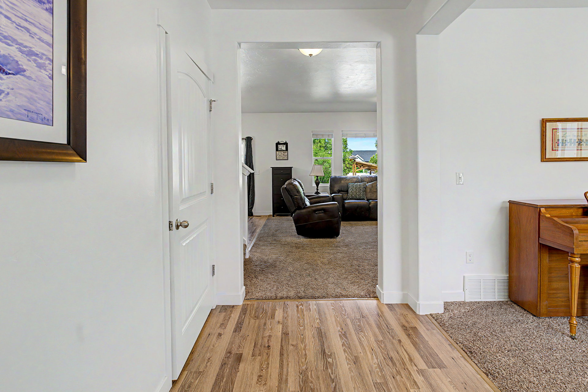 Entryway featuring wood-finish flooring, white trim, and a white interior door