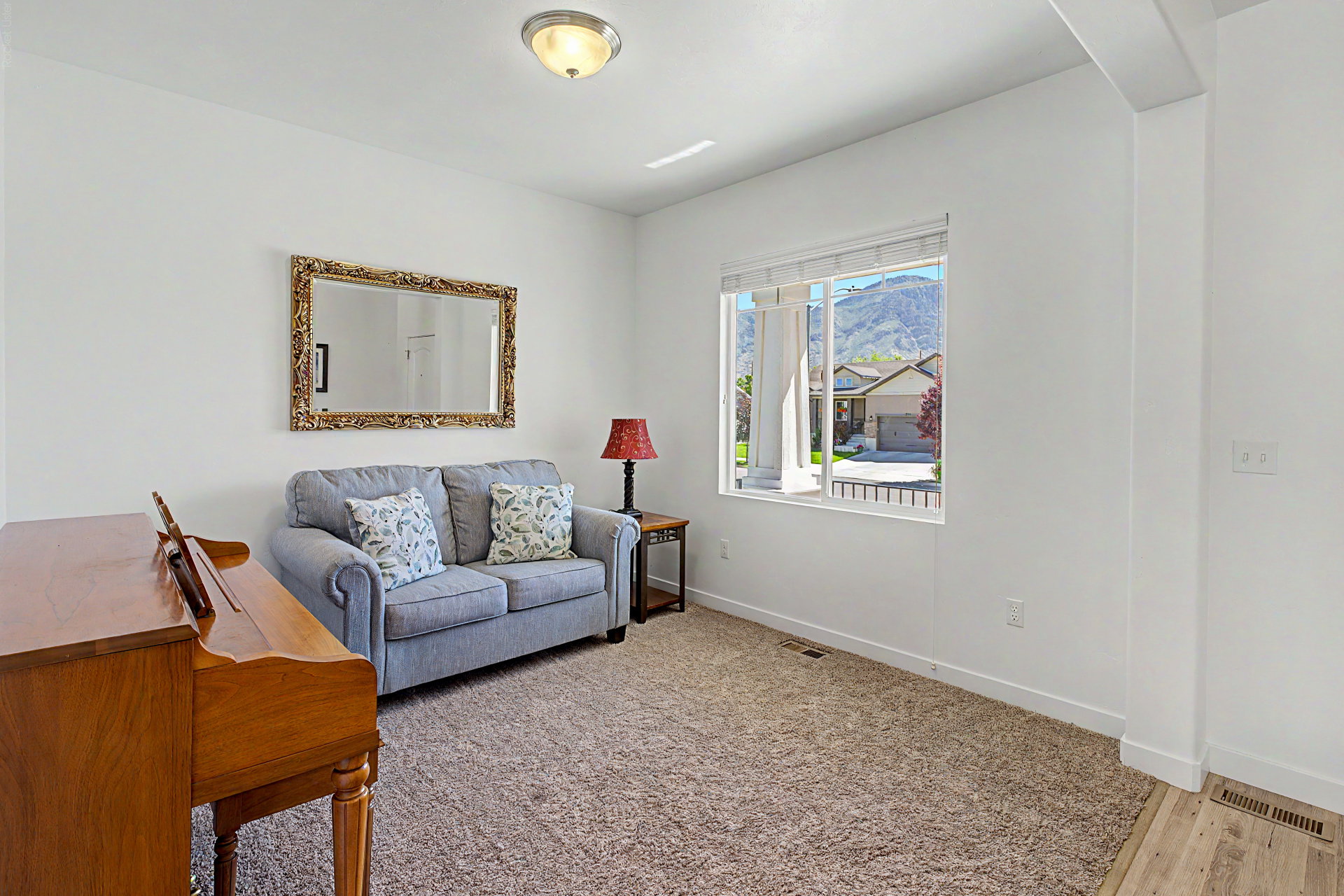 Carpeted room with a large window and mountain backdrop