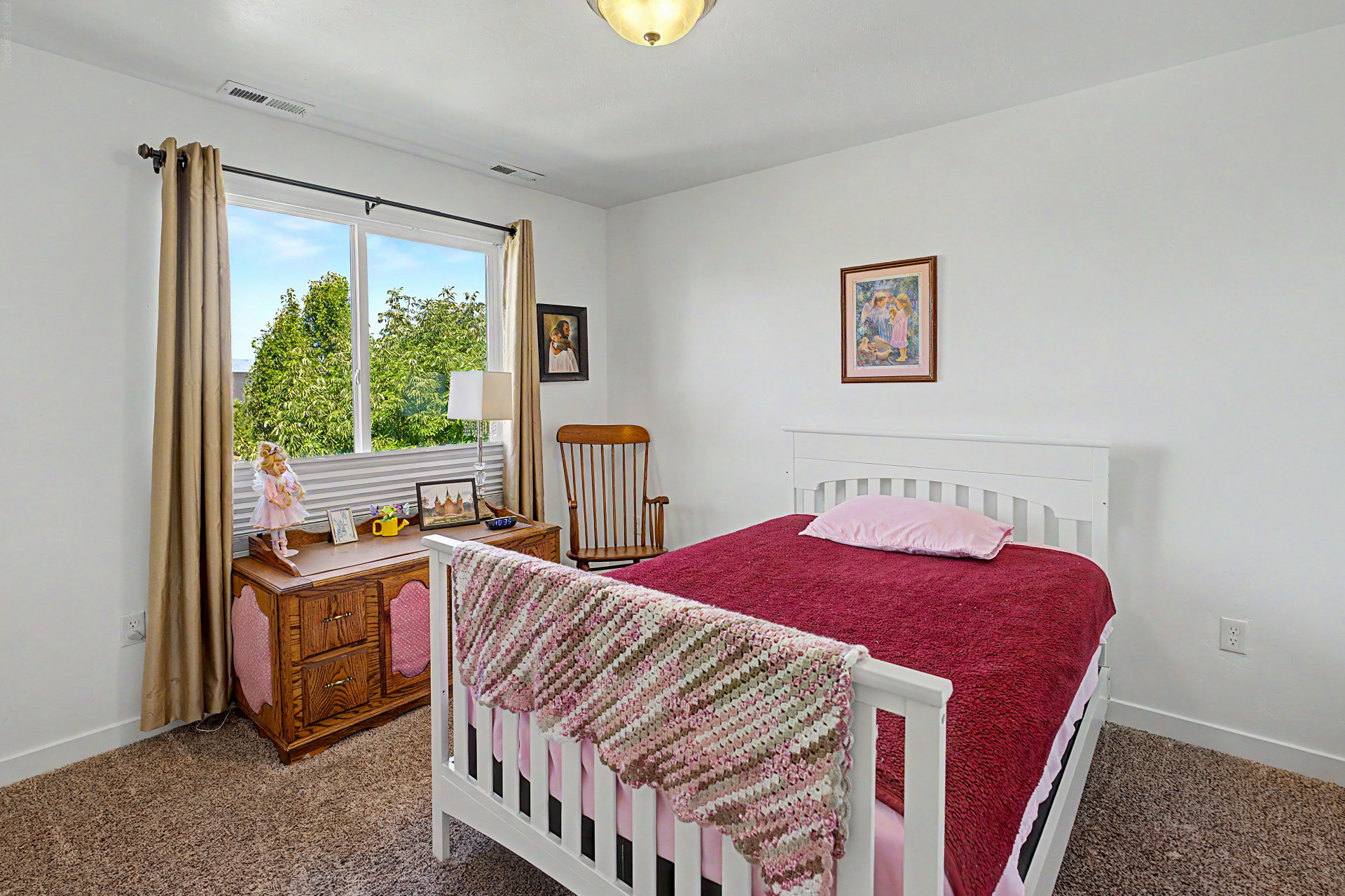 Bright room featuring white walls and neutral-toned carpeting